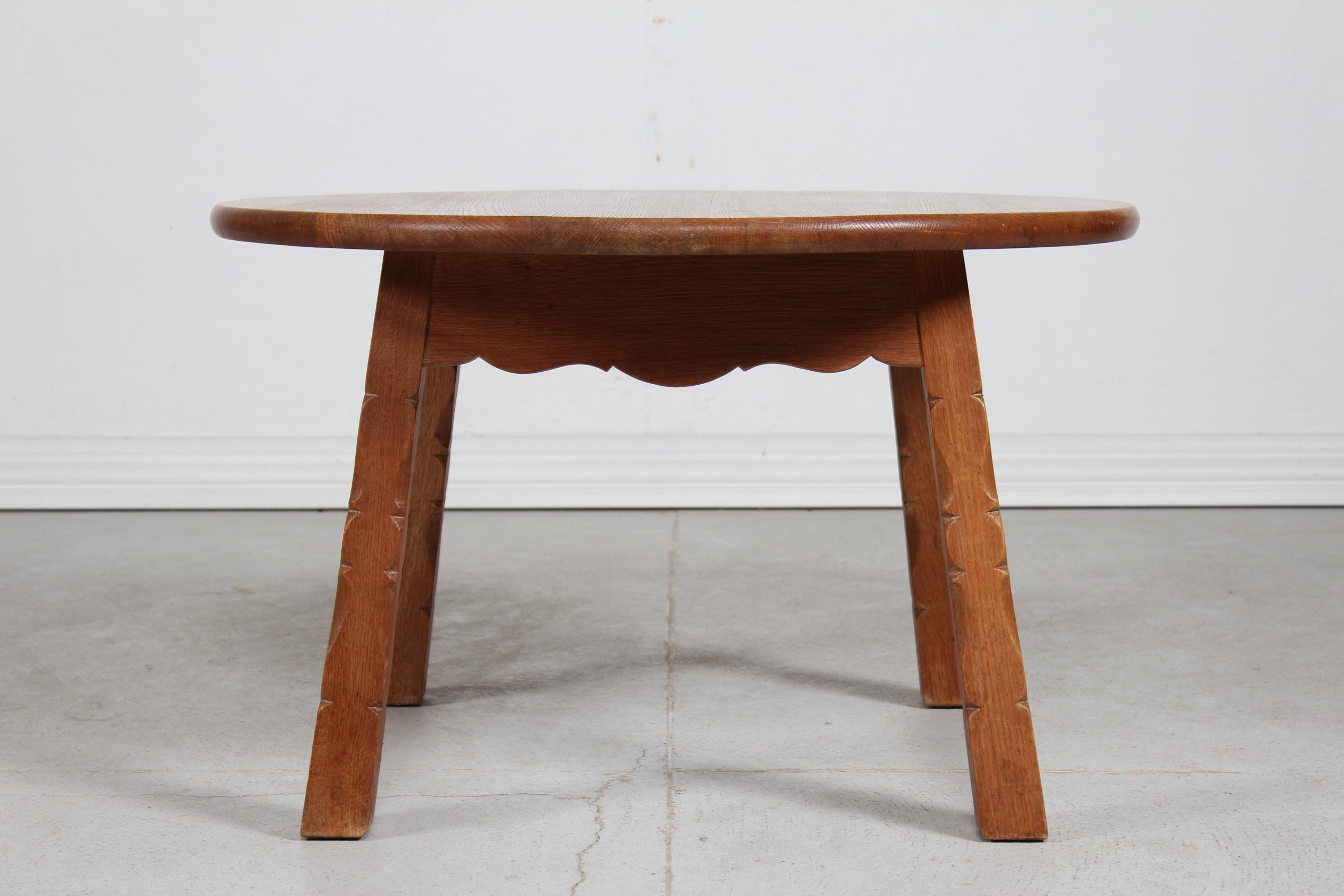 Round coffee table of heavy solid oak in the style of the designers as Henning Kjærnulf and Axel Einar Hjorth
Brutalist style with carved legs and wavy table rim.
Handmade by a danish cabinetmaker in the 1950s

Measures: Diameter 90 cm
Height 55.5
