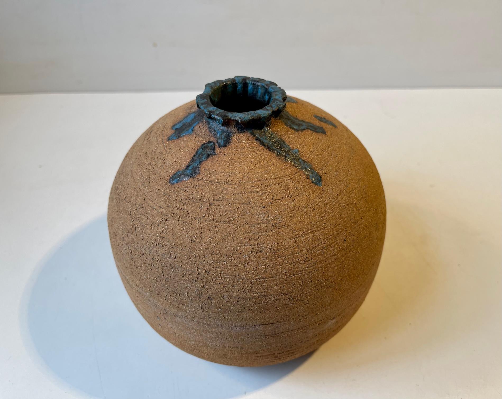 Interesting ball or onion shaped vase in un-glazed ceramic. It features intended spiky imperfections to its neck that are high-lighted with blue and black drip glaze. A funny mix of deconstructionism and constructivism. Its by an unidentified