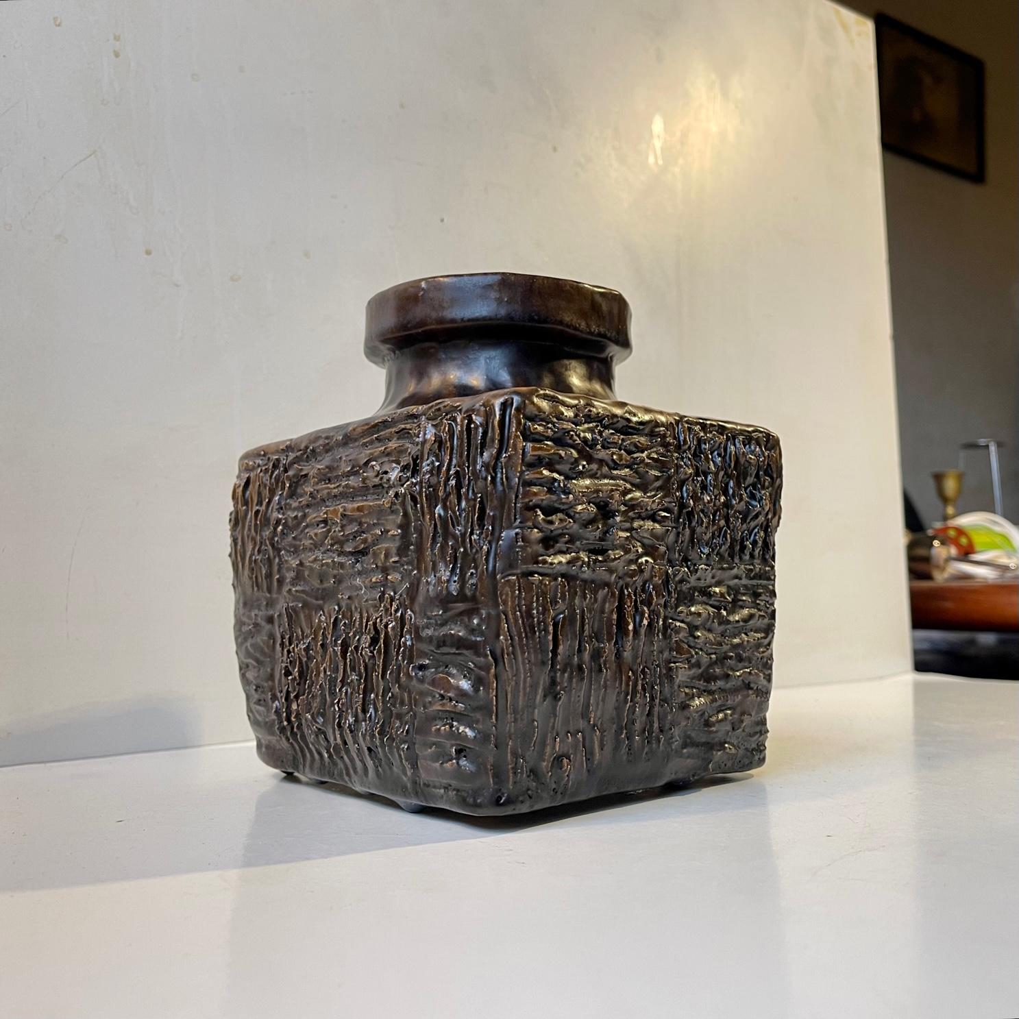 Interesting square - block shaped vase with Sgrafitto inspired incised ribbings with fat brown lava glaze. Its an unique piece by an unidentified Scandinavian Ceramist. It is hand signed and dated 1971. Measurements: H: 17 cm, W: 15 cm, Dept: 14 cm.