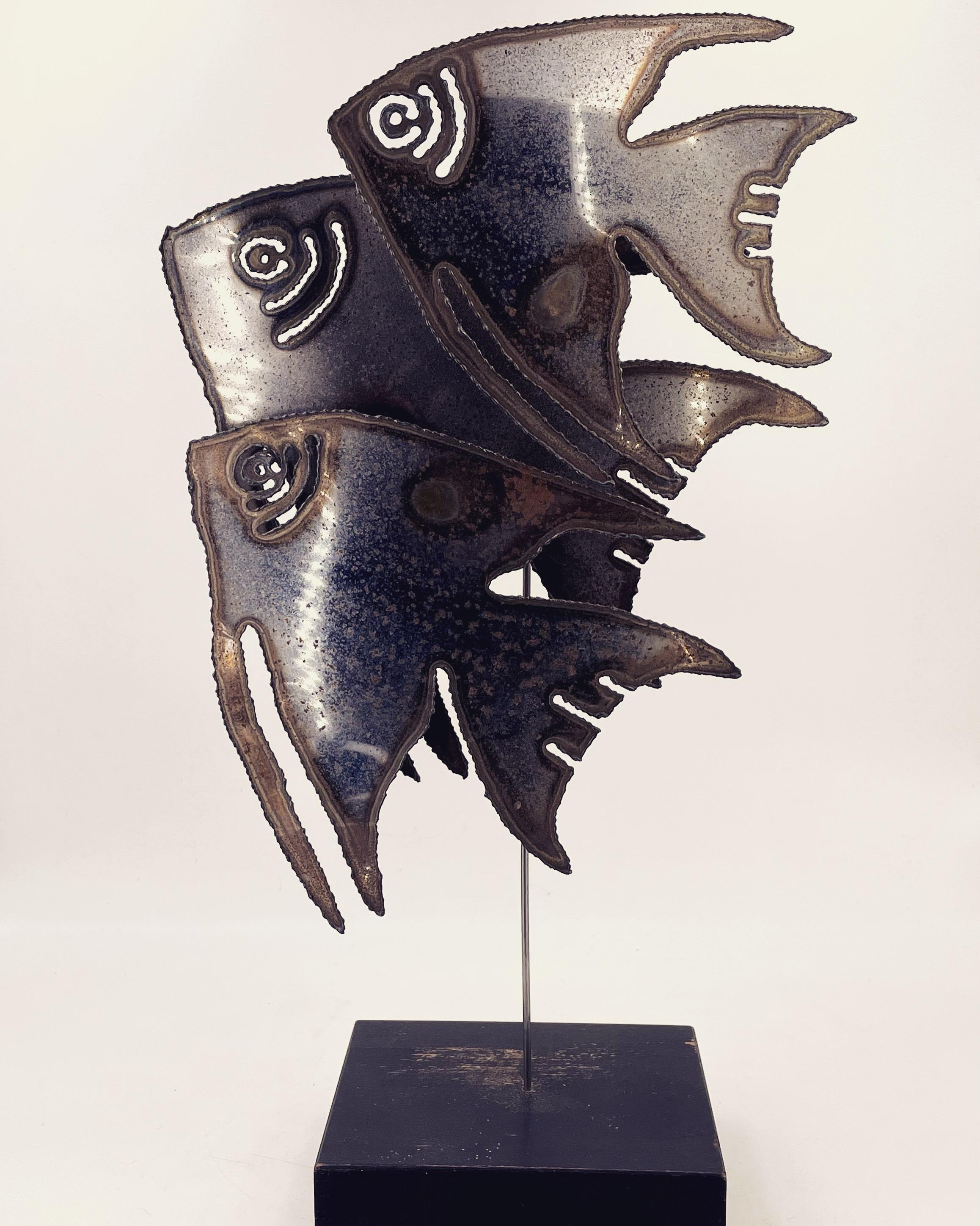 Cool and unique metal school of fish sculpture circa 1970s in chrome finish, sitting on black painted wood base, some light rust and wear shown due to age.