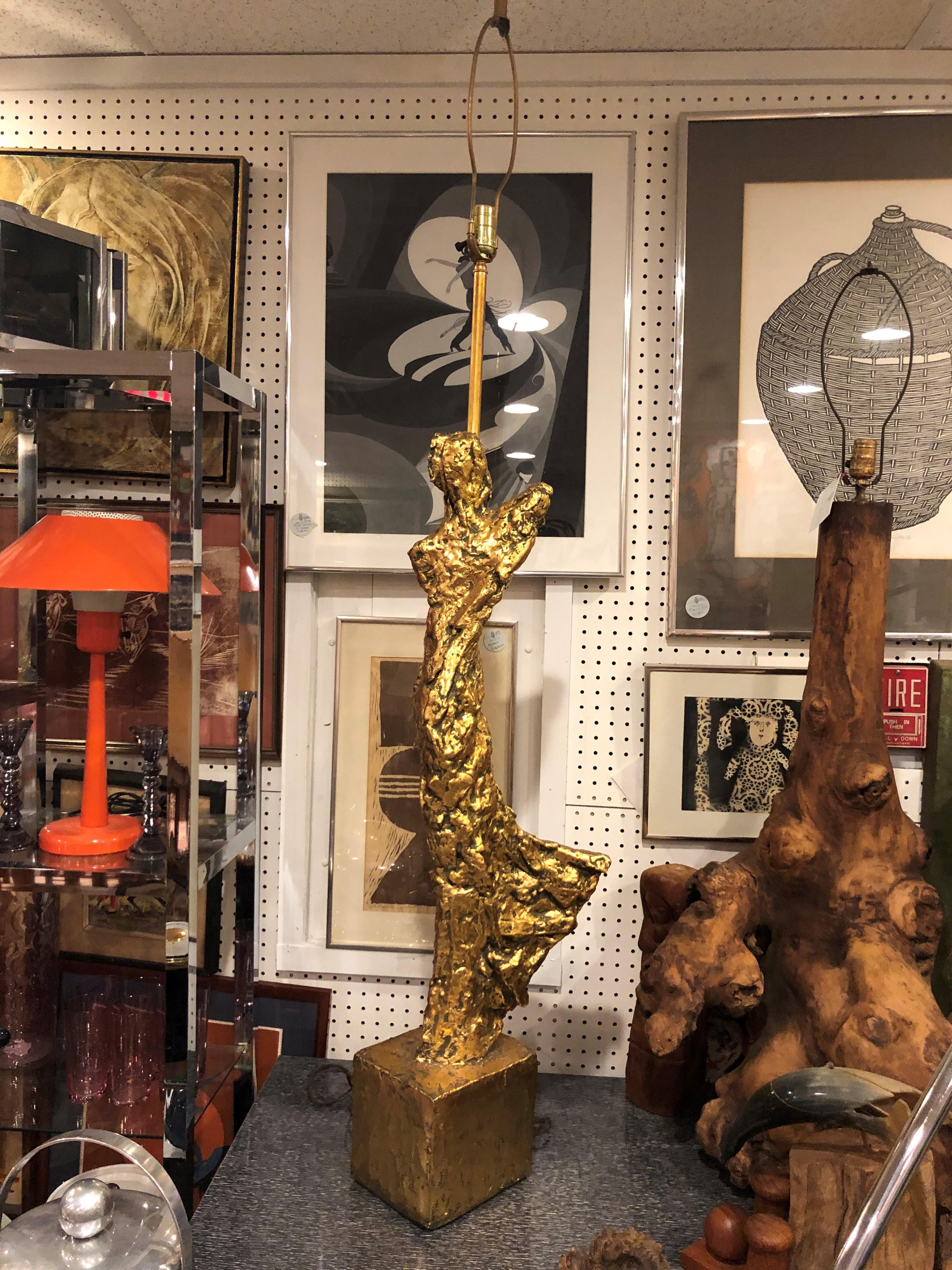 Brutalist sculptural lamp with gilt surface. Angelic in shape and elegant in movement this sculpture is united with illumination. Heavy gilded sculptural plaster. Has a large cylindrical metallic tortoiseshell lampshade.