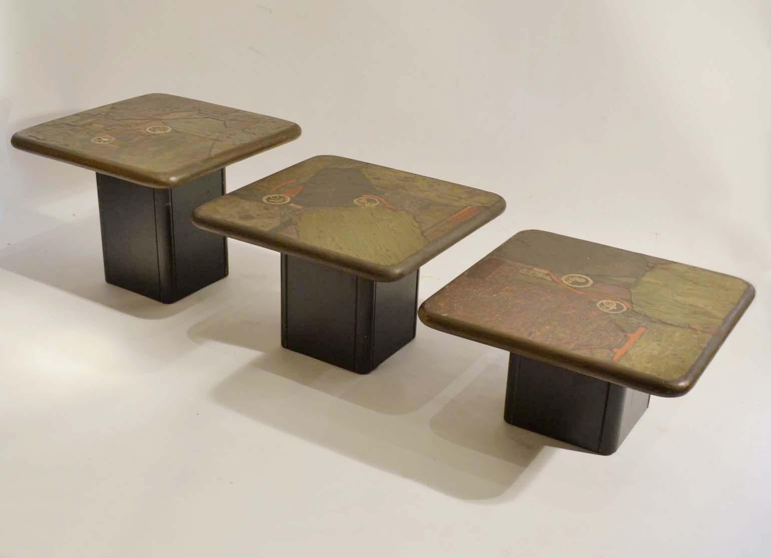 Set of three nesting natural stone mosaic side tables on alternating heights. The tables are inlaid with unpolished textural stone in earth colors and pieces of brass and copper. These extraordinary are square 60 x 60 cm tables with rounded corners