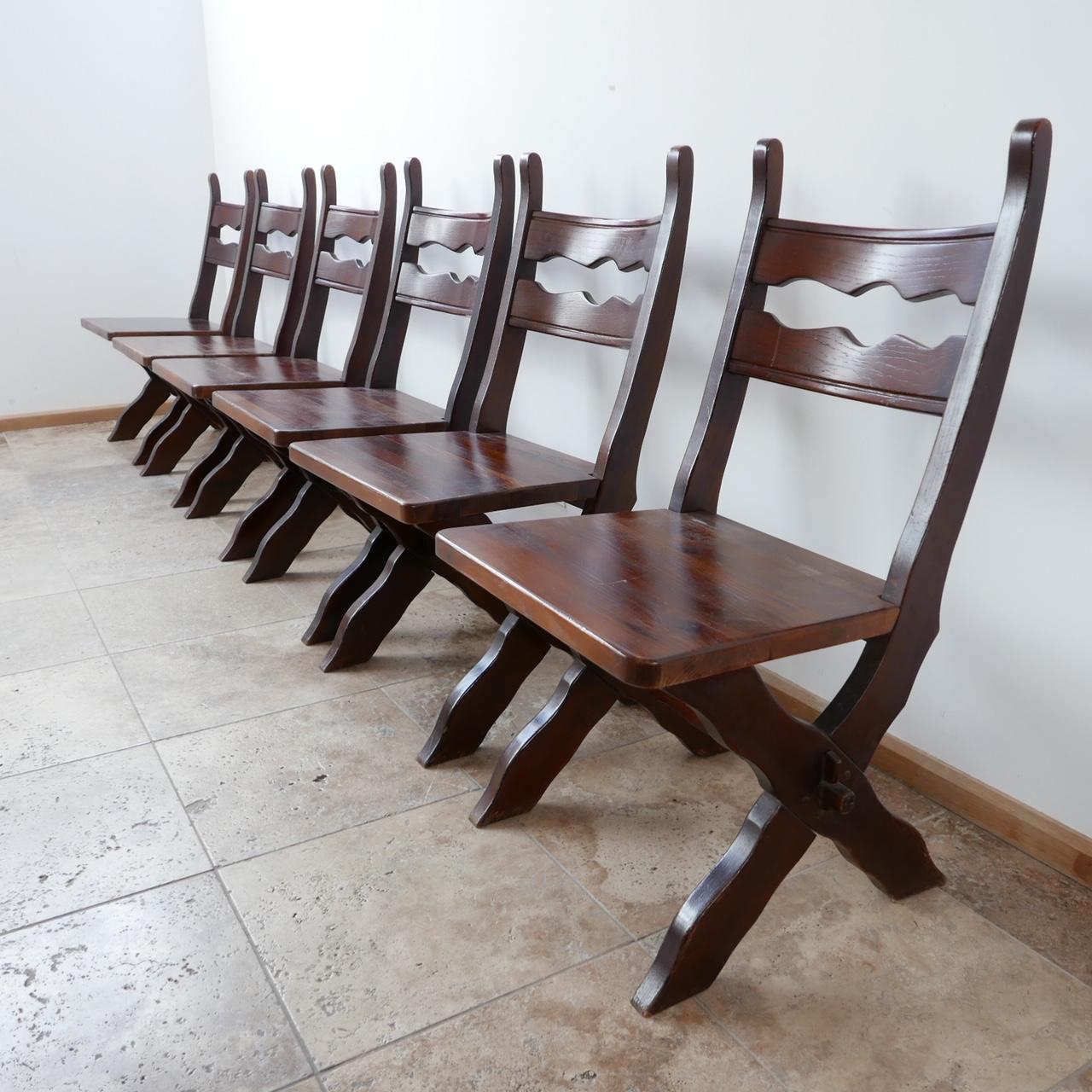 Un ensemble de six chaises de salle à manger. 

Belgique, c1980s. 

Bois teinté. 

De bonnes lignes fortes. 

Bon état général, quelques coups et éraflures correspondant à l'âge. 

Dimensions : 48 L x 53 P x 44 hauteur d'assise x 94