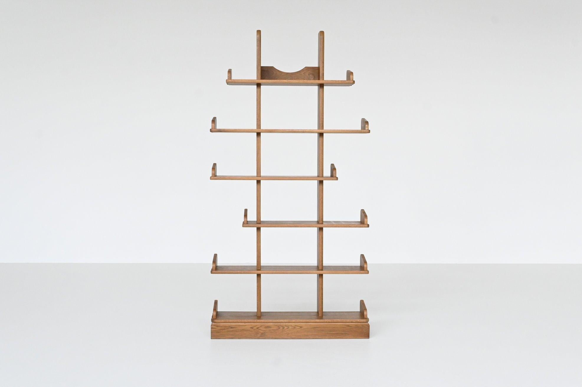 Very nice brutalist shelving unit or bookcase by unknown designer or manufacturer, The Netherlands 1970. This beautiful shaped shelving display unit is made of veneered oak wood with a nice warm grain. It has six shelves from different lengths which