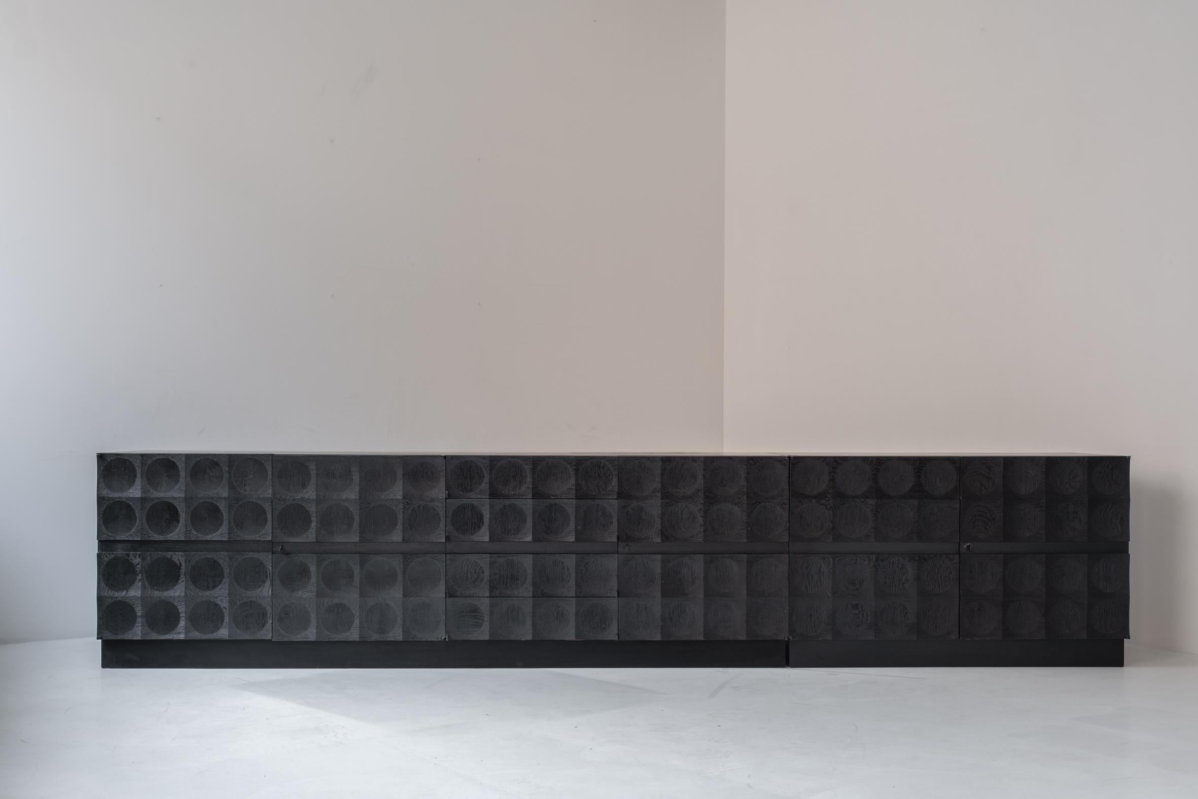 Brutalist large sideboard in black stained oak by J. Batenburg For MI, Belgium ca. 1969. This amazing sideboard features series of repeating carved patterns, which give the sideboard a strong appearance. This large credenza features a sideboard and