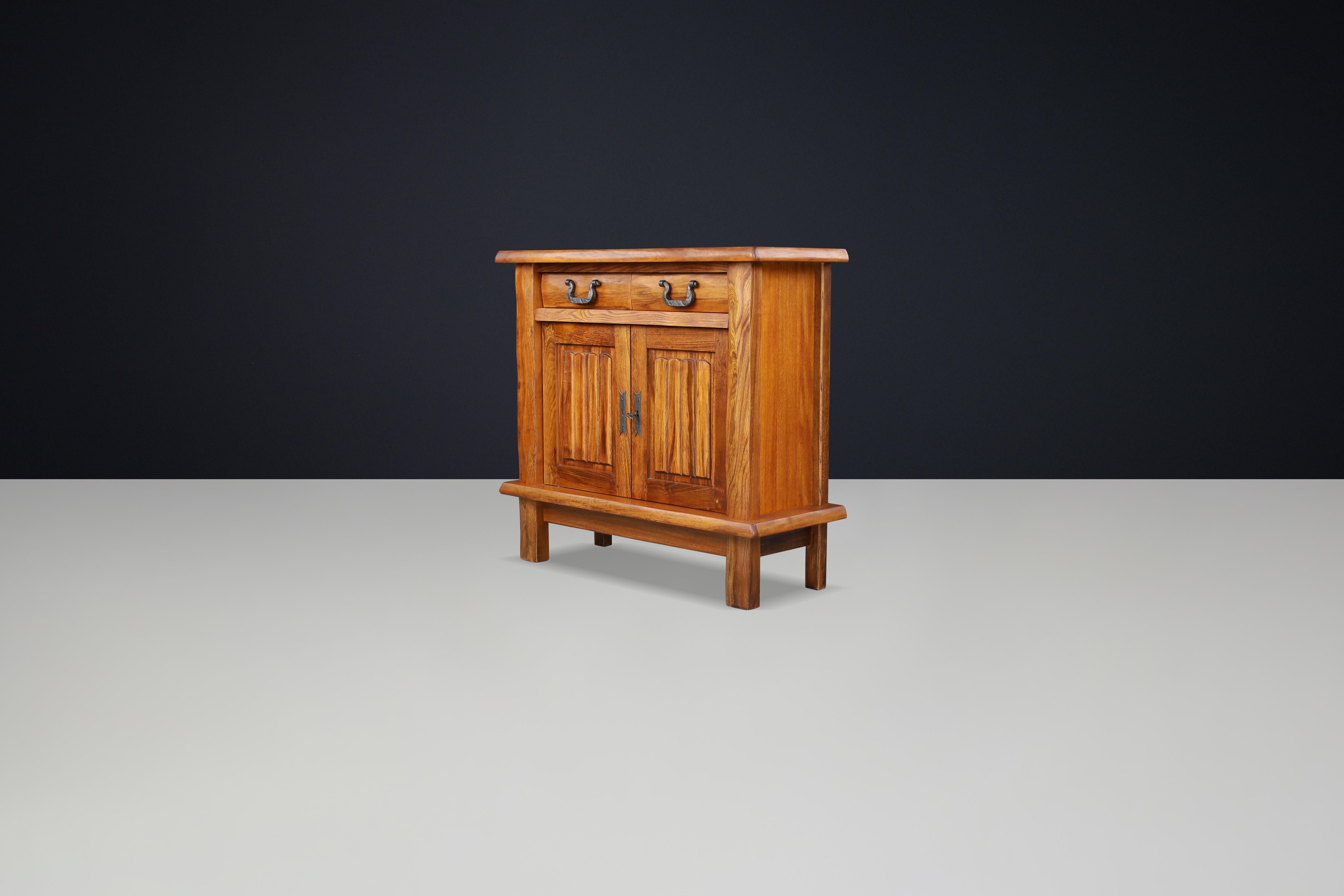 Brutalist Sideboard in Elm by Olavi Hänninen for Mikko Nupponen, Finland, 1958

This brutalist sideboard is crafted from solid elm and features a simplified design that highlights the natural beauty and grain of the wood. It includes two doors,