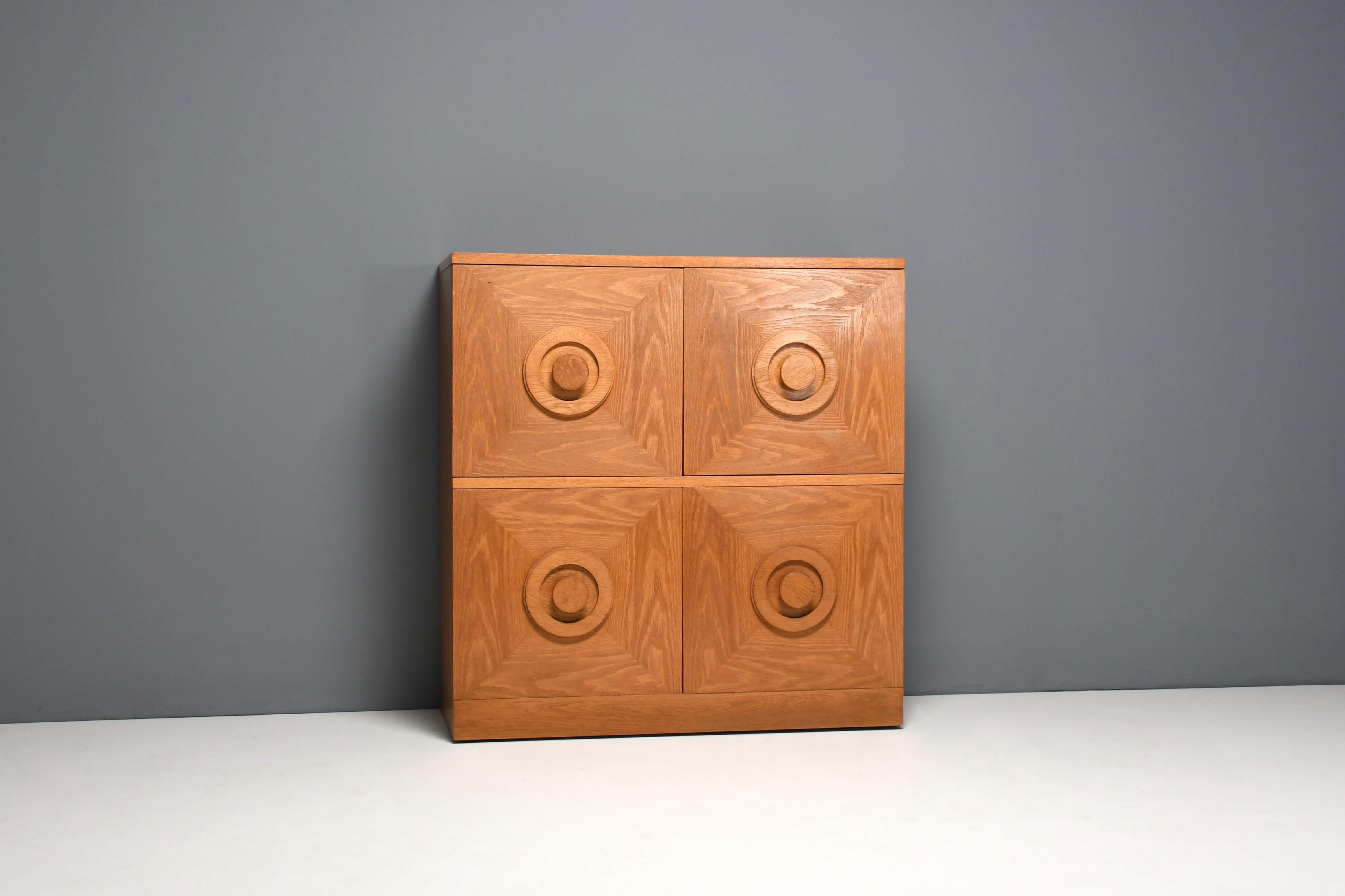 Beautiful brutalist cabinet in very good condition. 

Made in Belgium in the 1970s 

This sideboard has four doors made in a natural oak veneer, each door has a three-dimensional pattern.

The body of the cabinet is also made from oak veneer.