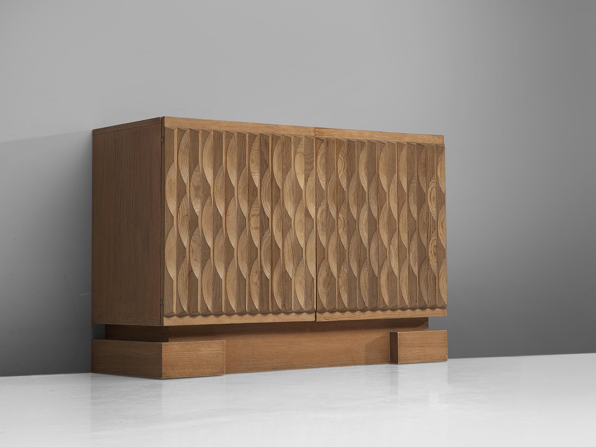 Sideboard, oak, Belgium, 1970s.

Wonderful Brutalist sideboard with very nice designed solid oak door panels. In the 1970s a few Belgium designers started experimenting with this kind of designs. Most of them worked with veneered panels and