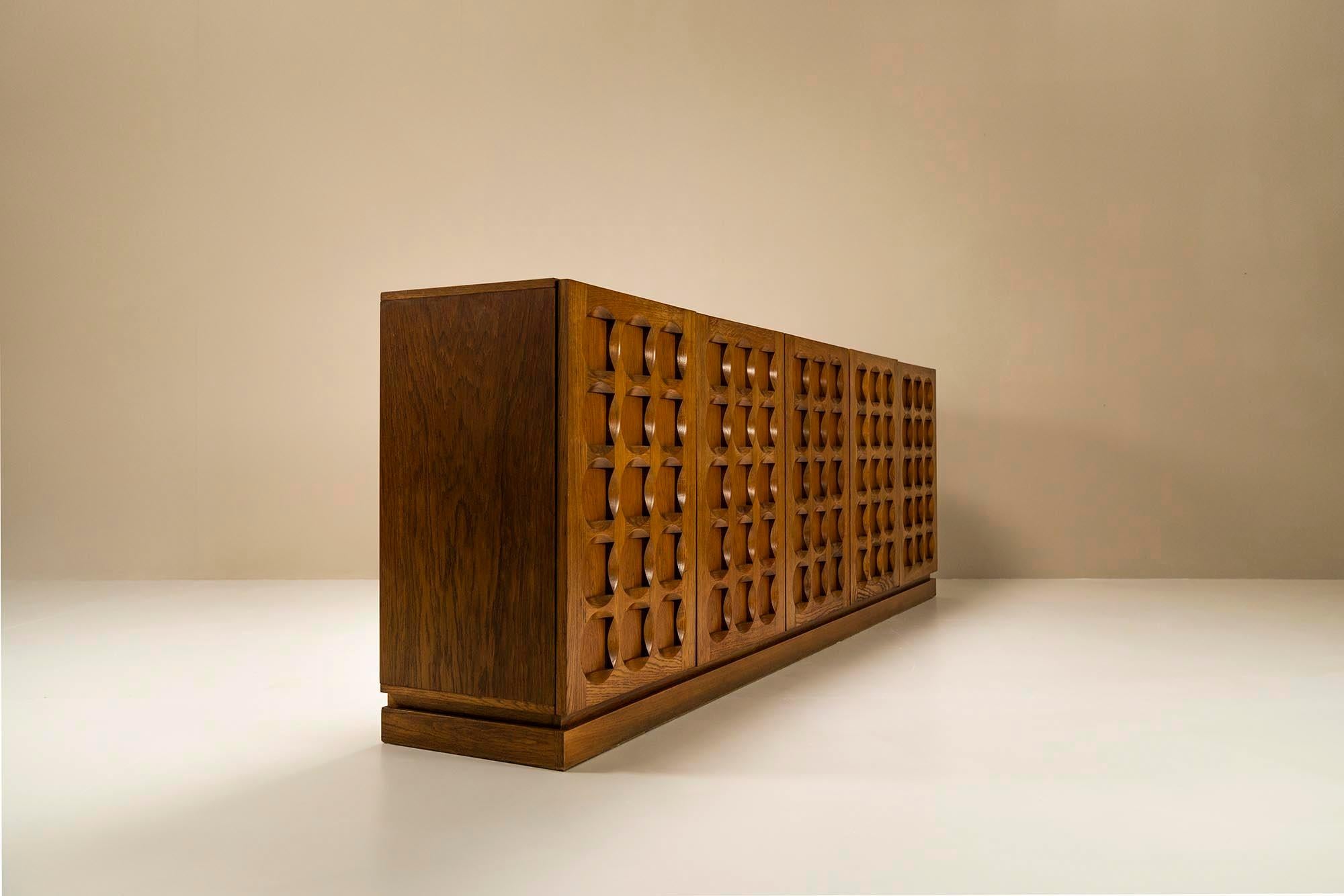 This sideboard was designed and manufactured in the early 1970s by the Belgian furniture company Defour. Typical for the Belgian design from that period is the brutalist style that is so recognizable and much loved up until today. The hypnotic