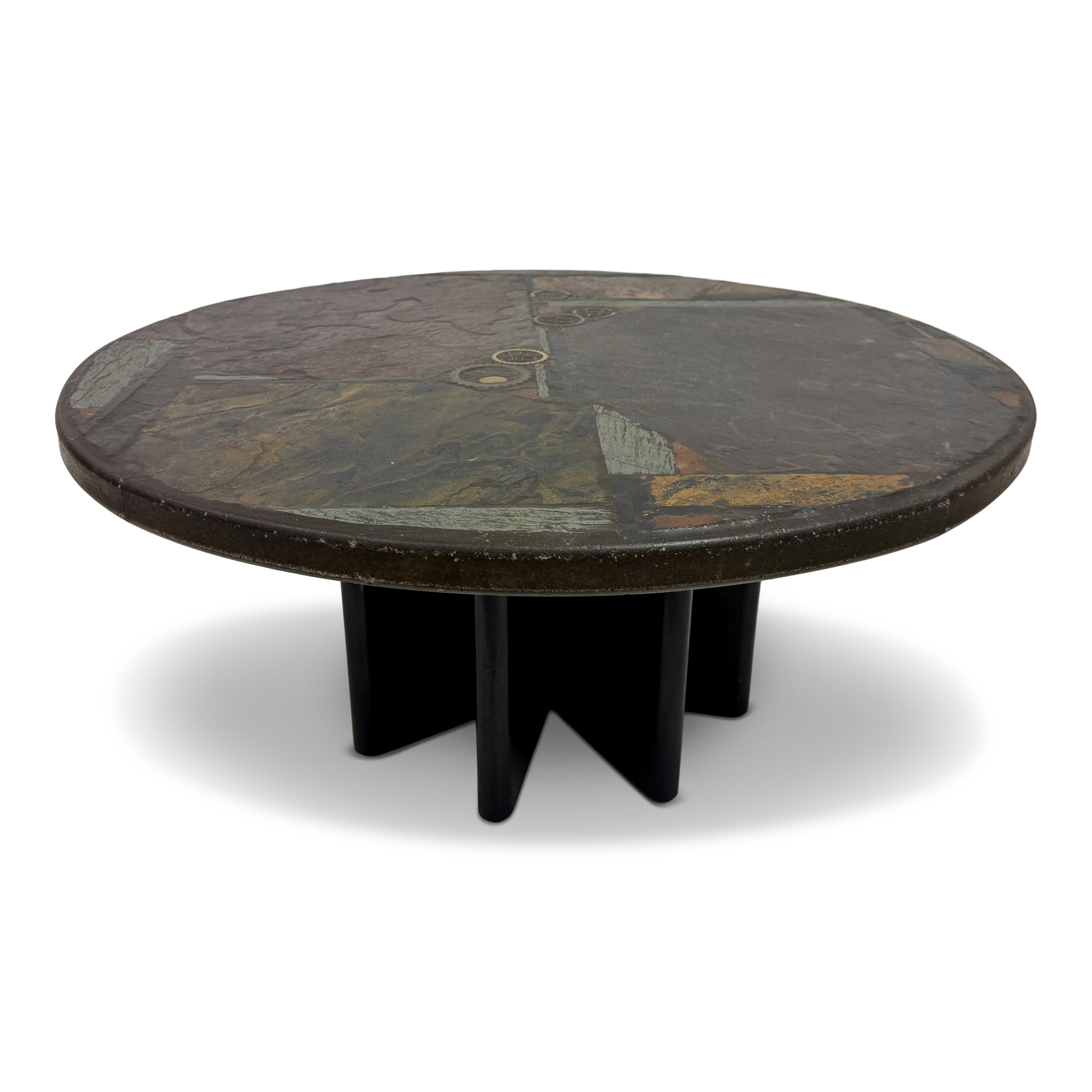 Brutalist Slate and Stone Coffee Table in the Style of Paul Kingma, 1970s

A striking Brutalist coffee table in the manner of Dutch artist Paul Kingma, dating to the 1970s. The circular top is an expressive mosaic of slate, stone, and inlaid brass,