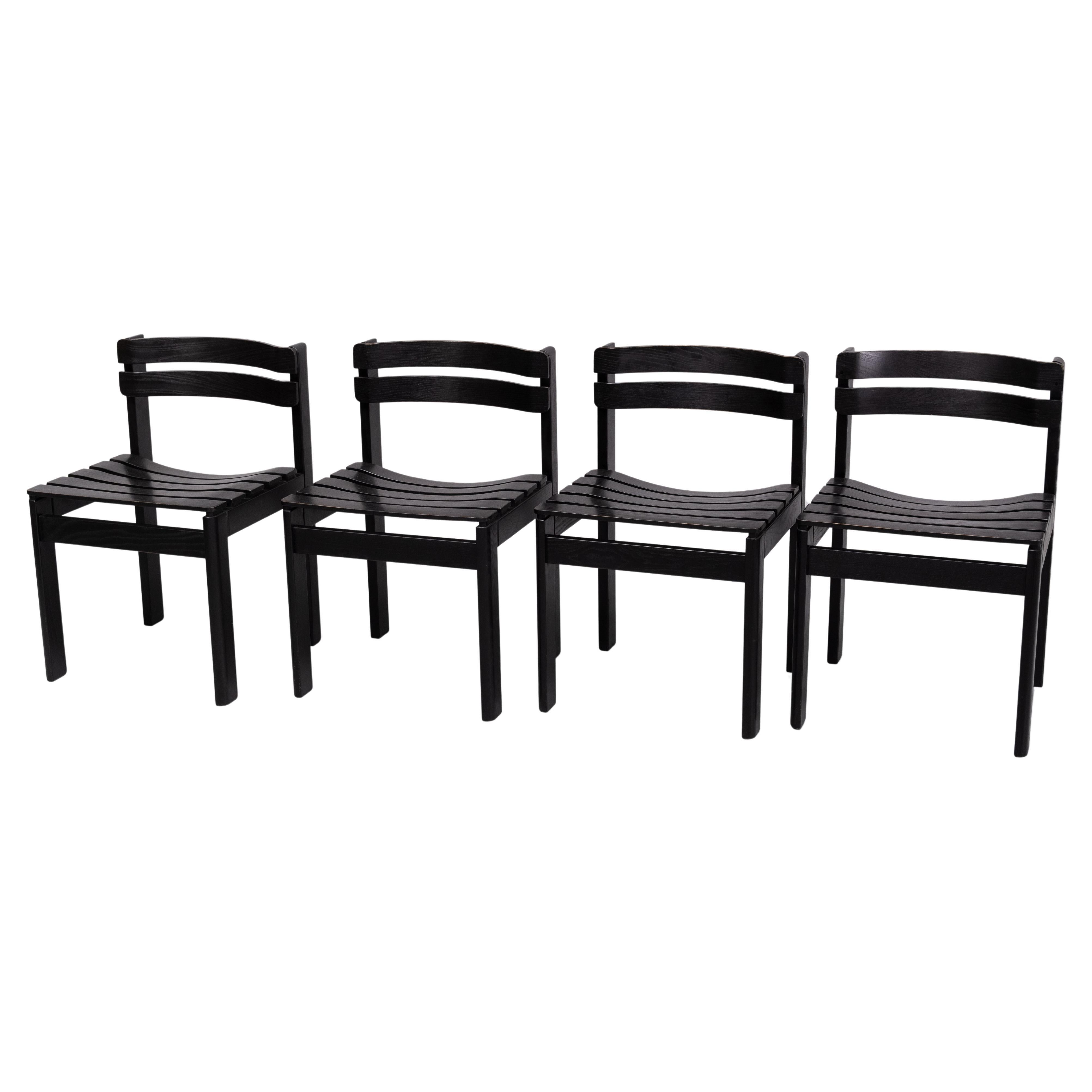 The chairs feature a solid Oak wood structure that has been painted black. The design in particularly appealing because of its curved slats, both for the seat and backrest. The backrest slats are positioned in a sort of forward design. The overall
