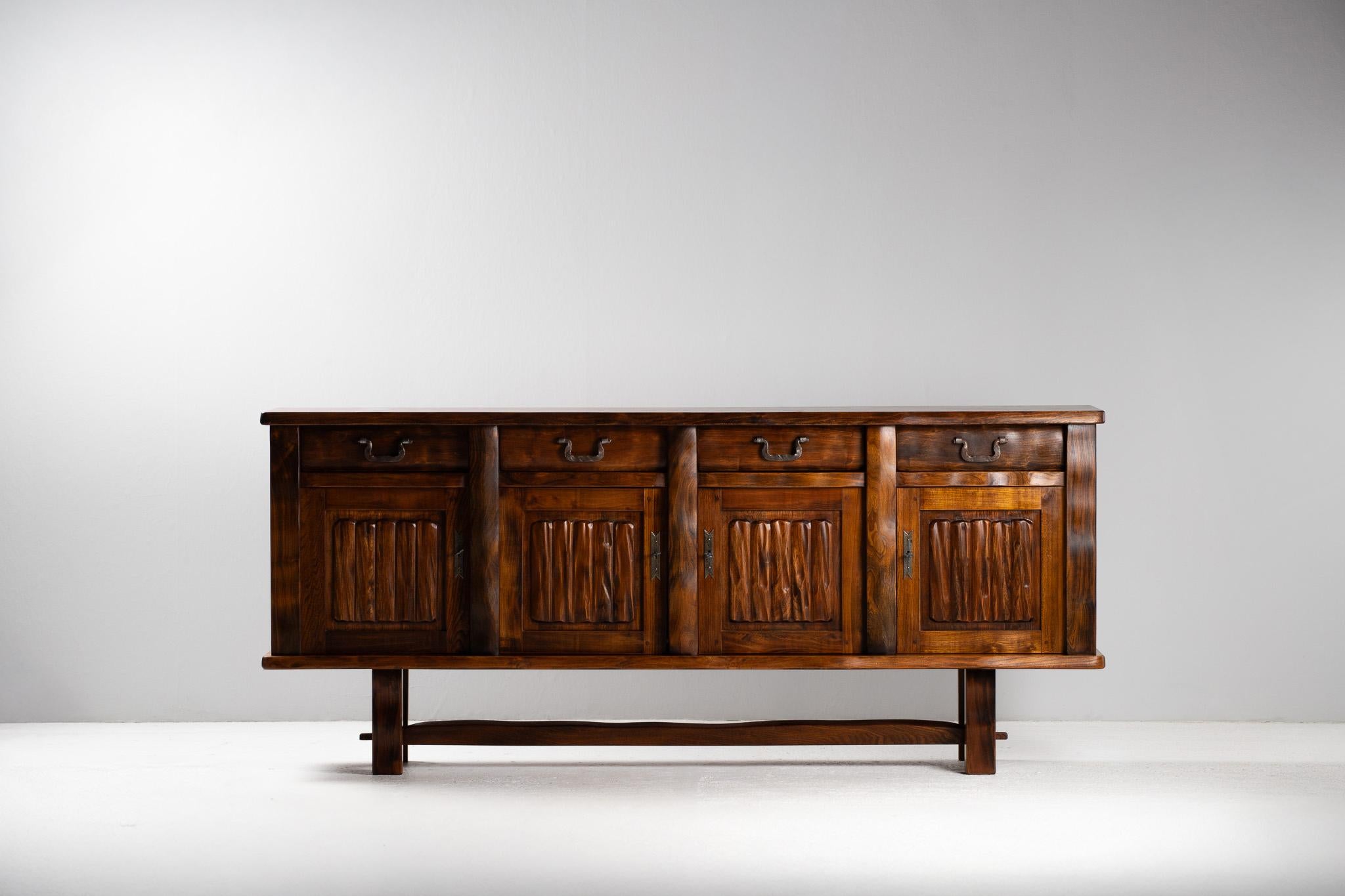 
Dieses schlichte, aber haptisch reizvolle Sideboard von Olavi Hänninen besticht durch seine elementare Masse und seine rohe skulpturale Präsenz. Die aus tief gemaserter Ulme gefertigte Fassade wird durch vertikale Rillen belebt - jede Rille ist