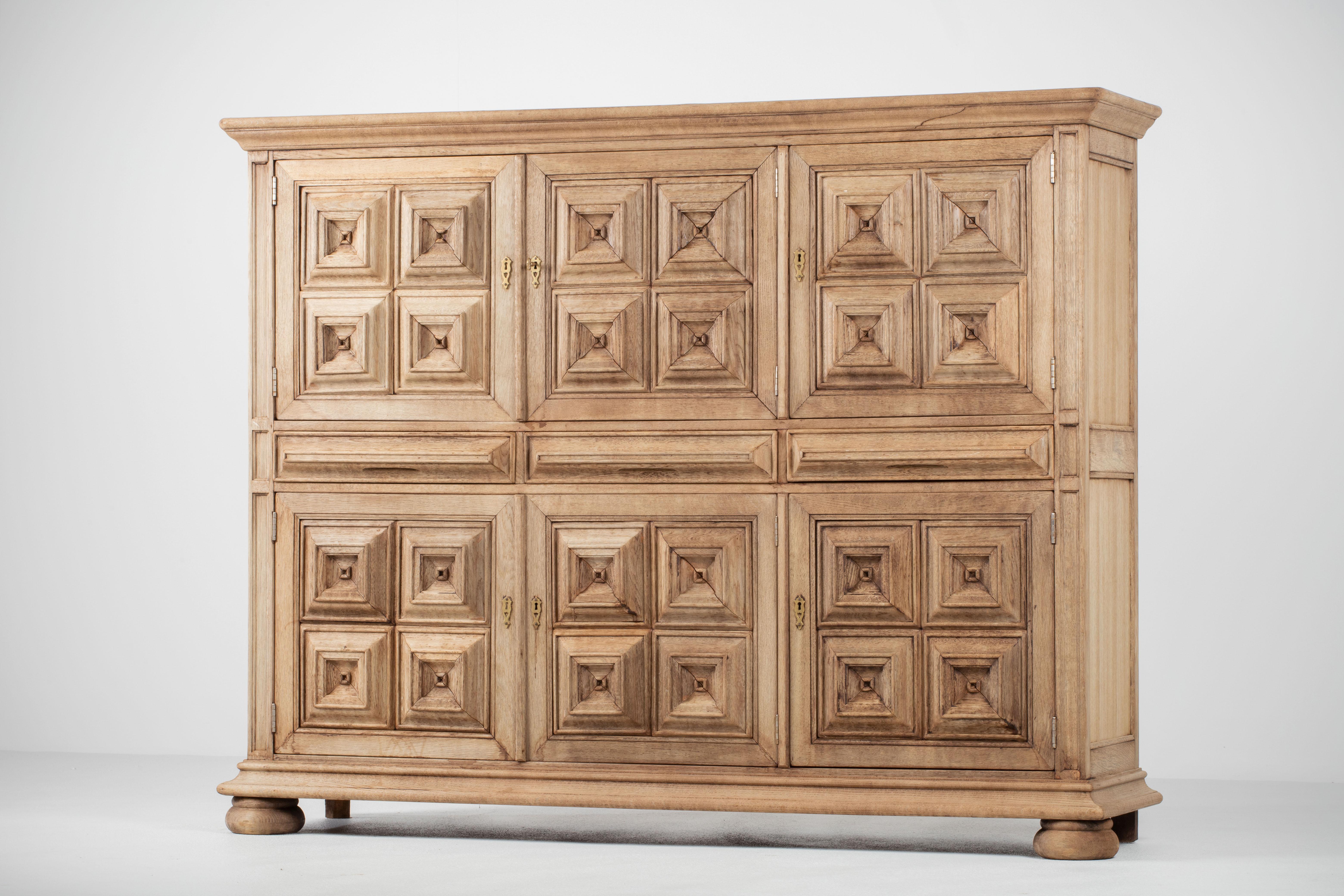 Brutalist solid oak sideboard, credenza, Spanish Colonial. The highboard features stunning Oak structure on door panels. It offers ample storage, with shelve behind the doors. A unique blend of Art Deco Spanish and Brutalist Modern design. The