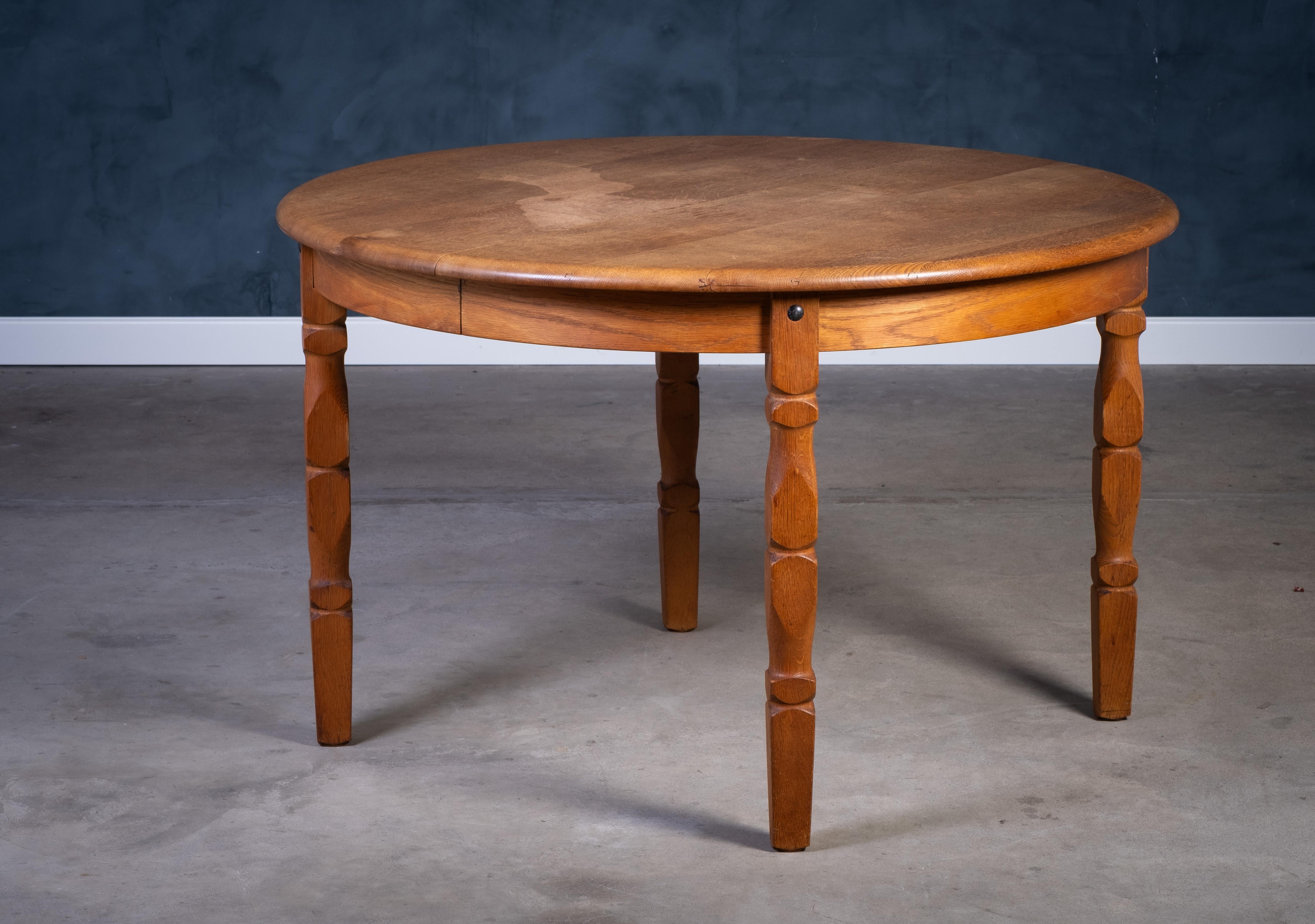 Dining table in solid oak, designed by Henning Kjærnulf in the 1970s. The table features a strong Brutalist aesthetic and includes two extension leaves, allowing it to accommodate around 10–12 people. The piece is in very good condition for its age,