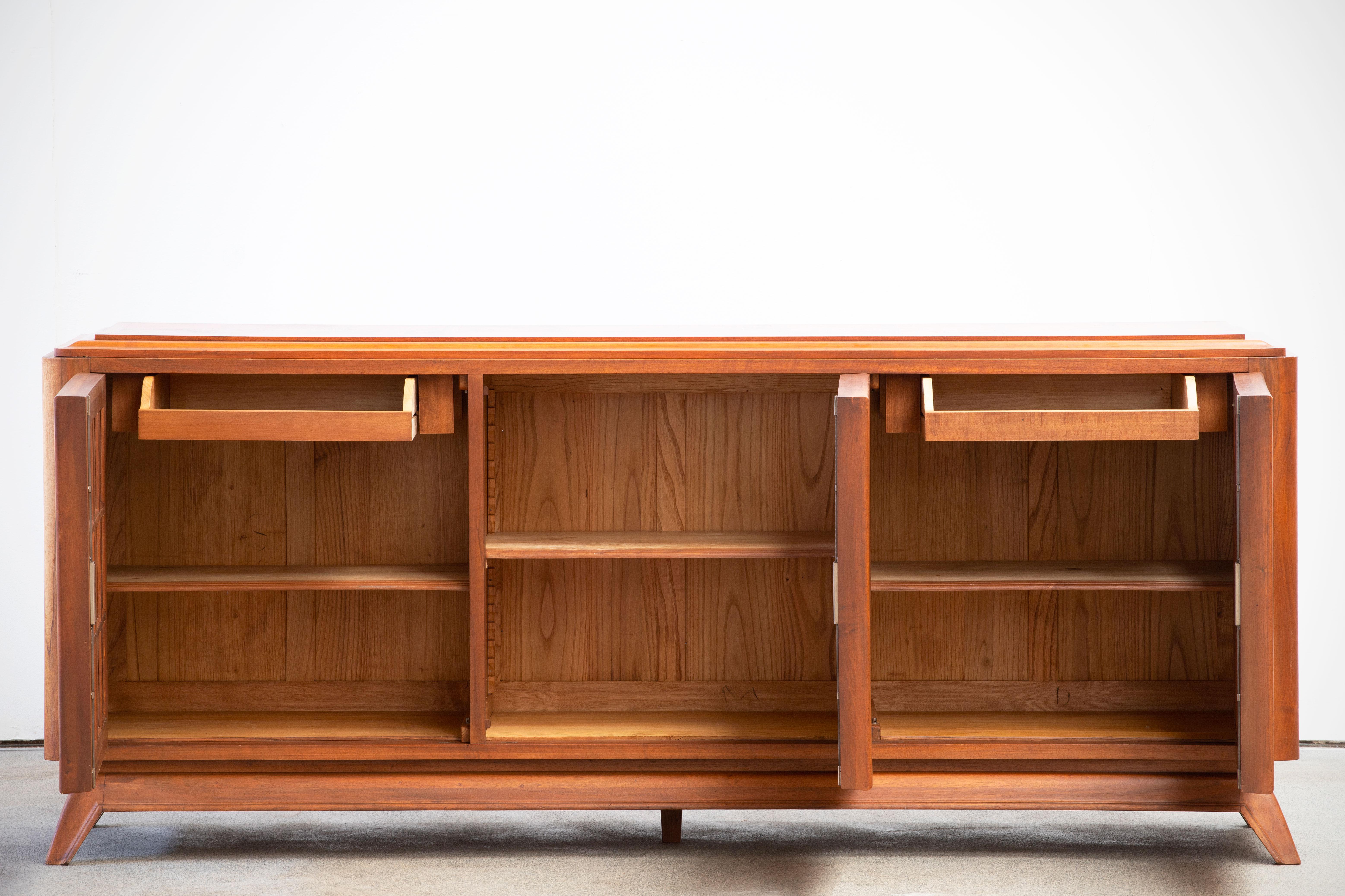 Credenza, solid oak, France, 1940s.
Large Art Deco Brutalist sideboard. This heavy Brutalist credenza seems to float on its elegant base. The credenza consists of three large storage facilities and covered with very detailed designed door panels.