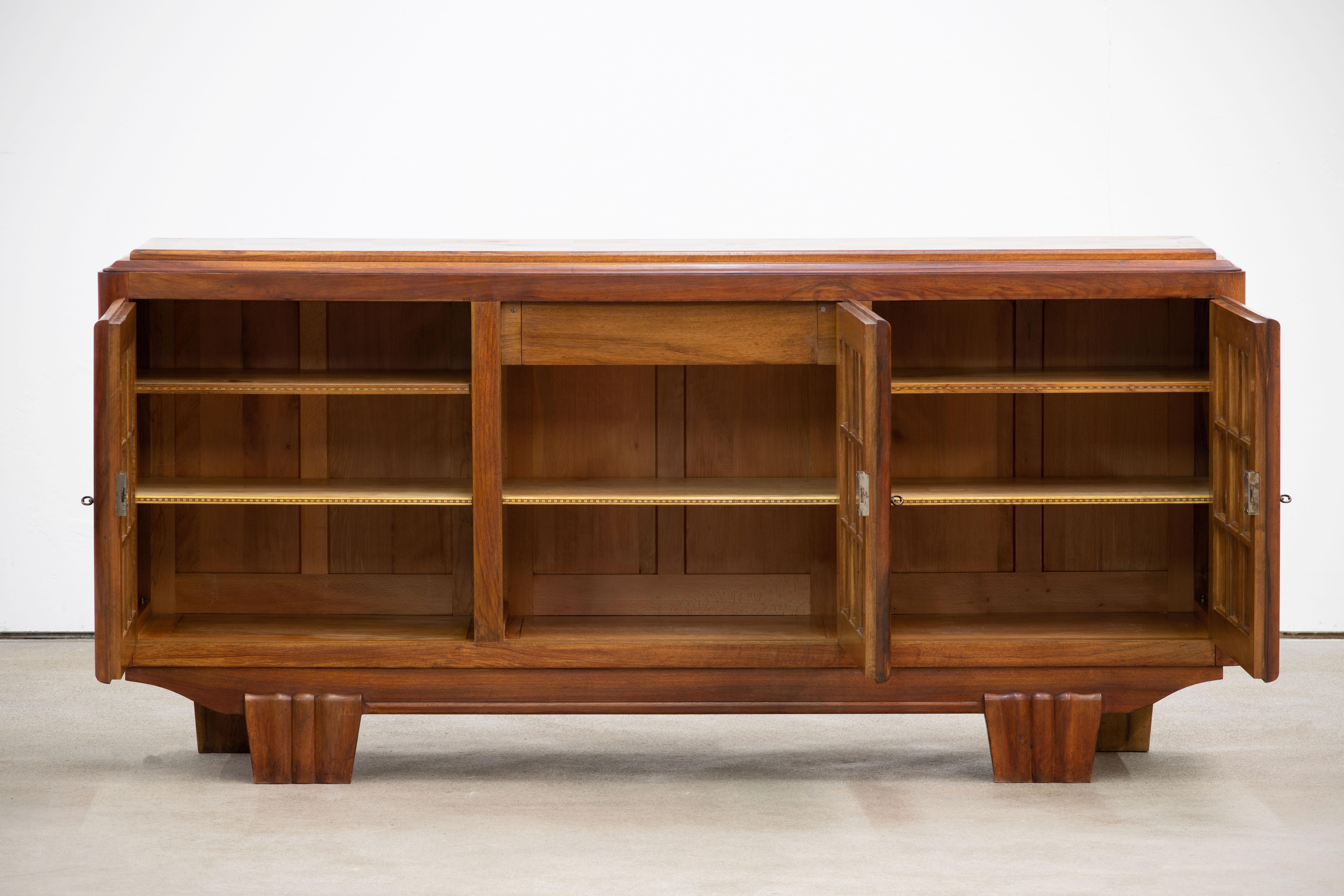 Credenza, solid oak, France, 1940s.
Large Art Deco Brutalist sideboard. This heavy Brutalist credenza seems to float on its elegant base. The credenza consists of three large storage facilities and covered with very detailed designed door panels.