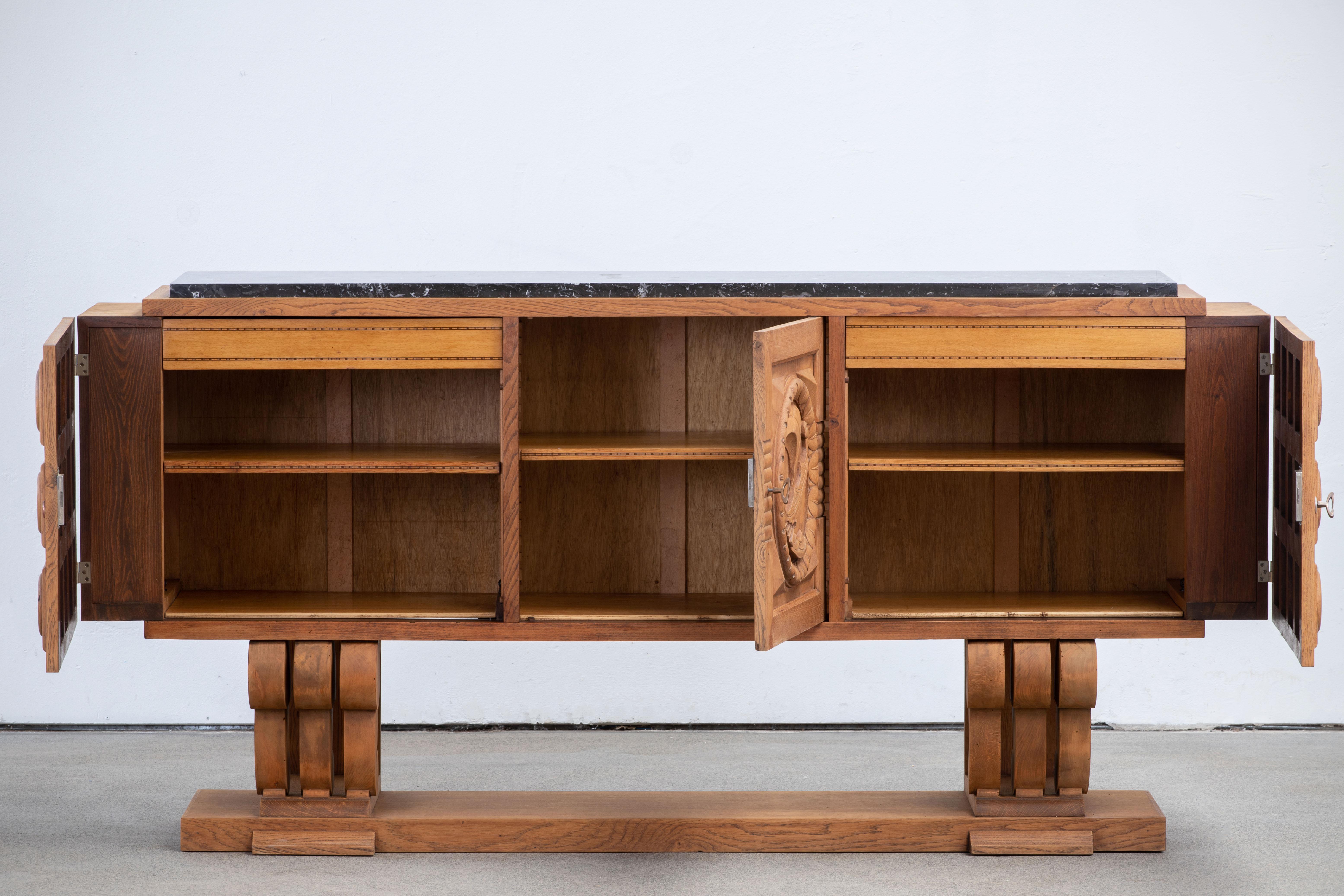 Credenza, solid oak, France, 1940s.
Large Art Deco Brutalist sideboard. This heavy Brutalist credenza seems to float on its elegant base. The credenza consists of two large storage facilities and covered with very detailed diamond designed door