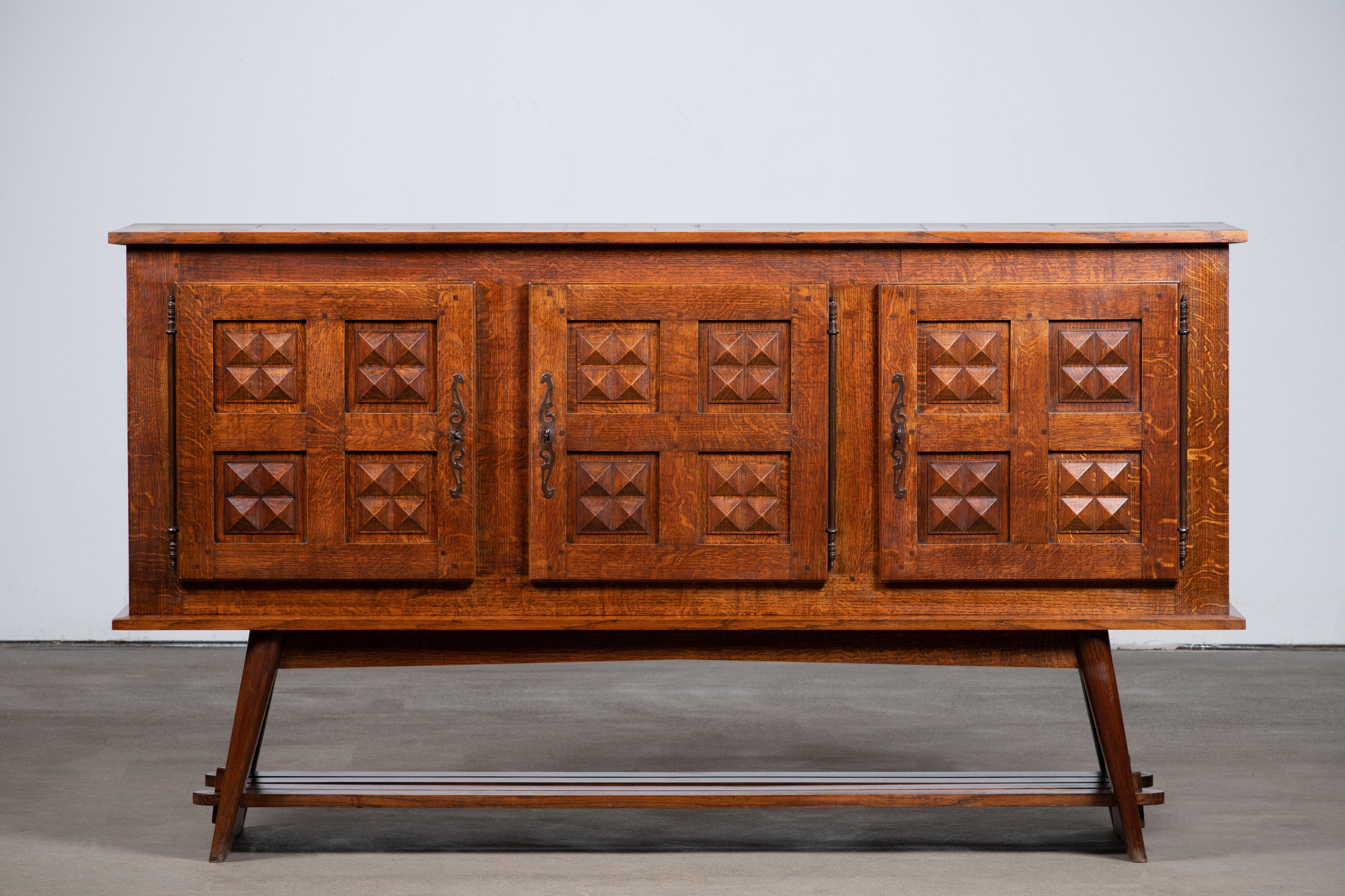 Constructivism Credenza, solid oak, France, 1940s.
Large Art Deco Brutalist sideboard. 
The credenza consists of tree storage facilities with shelves covered with very detailed designed door panels, a lower shelve 
A low slatted shelf completes