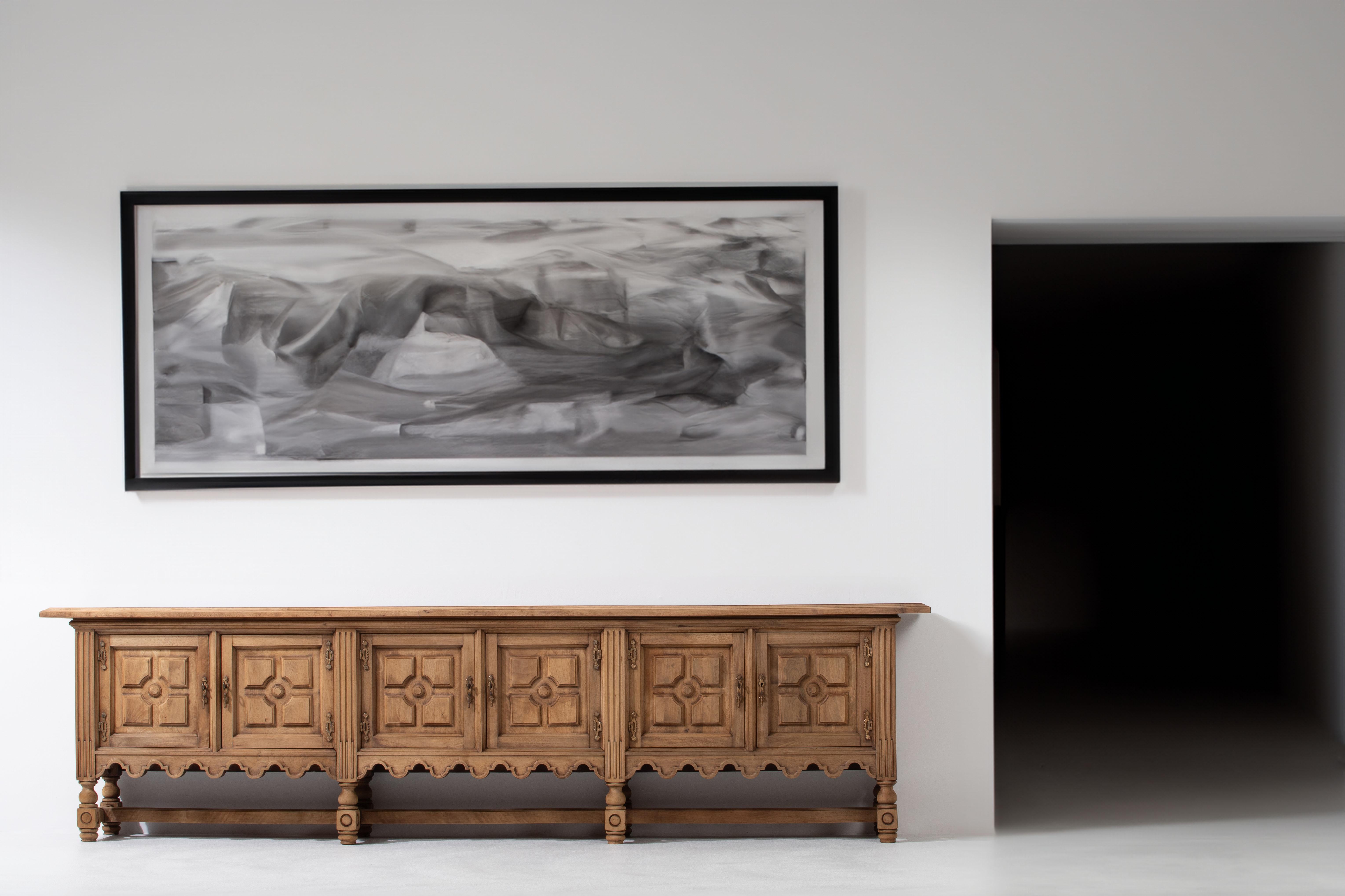 Step into the world of sensory delight with this stunning 3-meter-long sideboard, a masterpiece that celebrates the rich history of Spanish Brutalist inspiration. Crafted from solid walnut, the touch of the wood under your fingertips reveals the