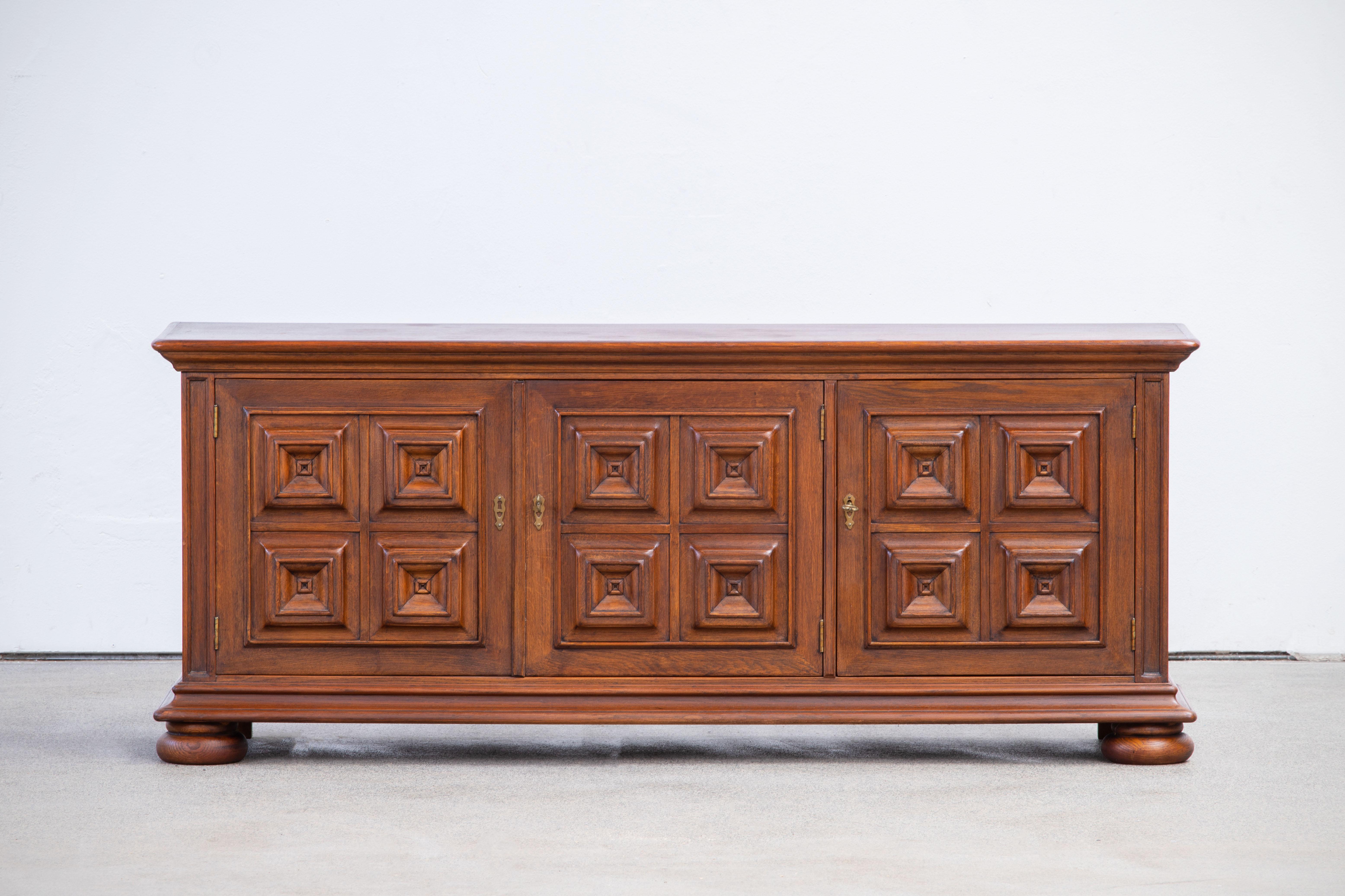 Brutalist solid oak sideboard, credenza, Spanish Colonial. The buffet features stunning Oak structure on door panels. It offers ample storage, with shelve behind the doors. A unique blend of Art Deco Spanish and Brutalist Modern design. The