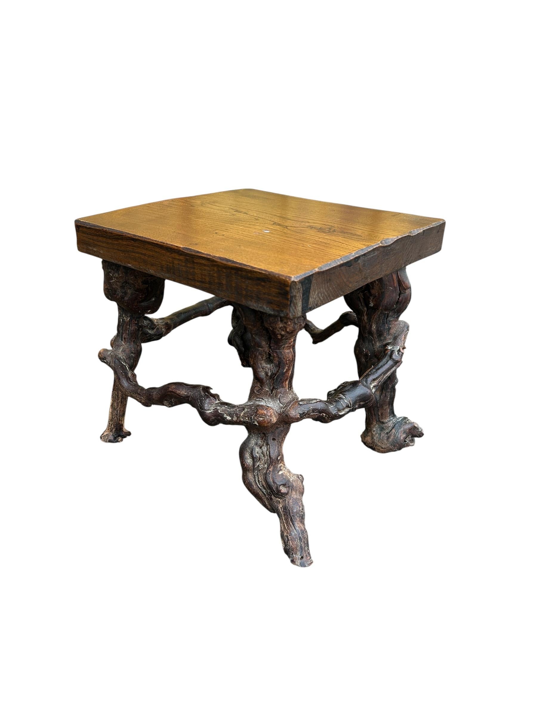  French side table with a grapevine base from the mid century 
This table features a round wooden slab top with carved scalloped edges, with a natural grapevine base , all in an organic fashion.