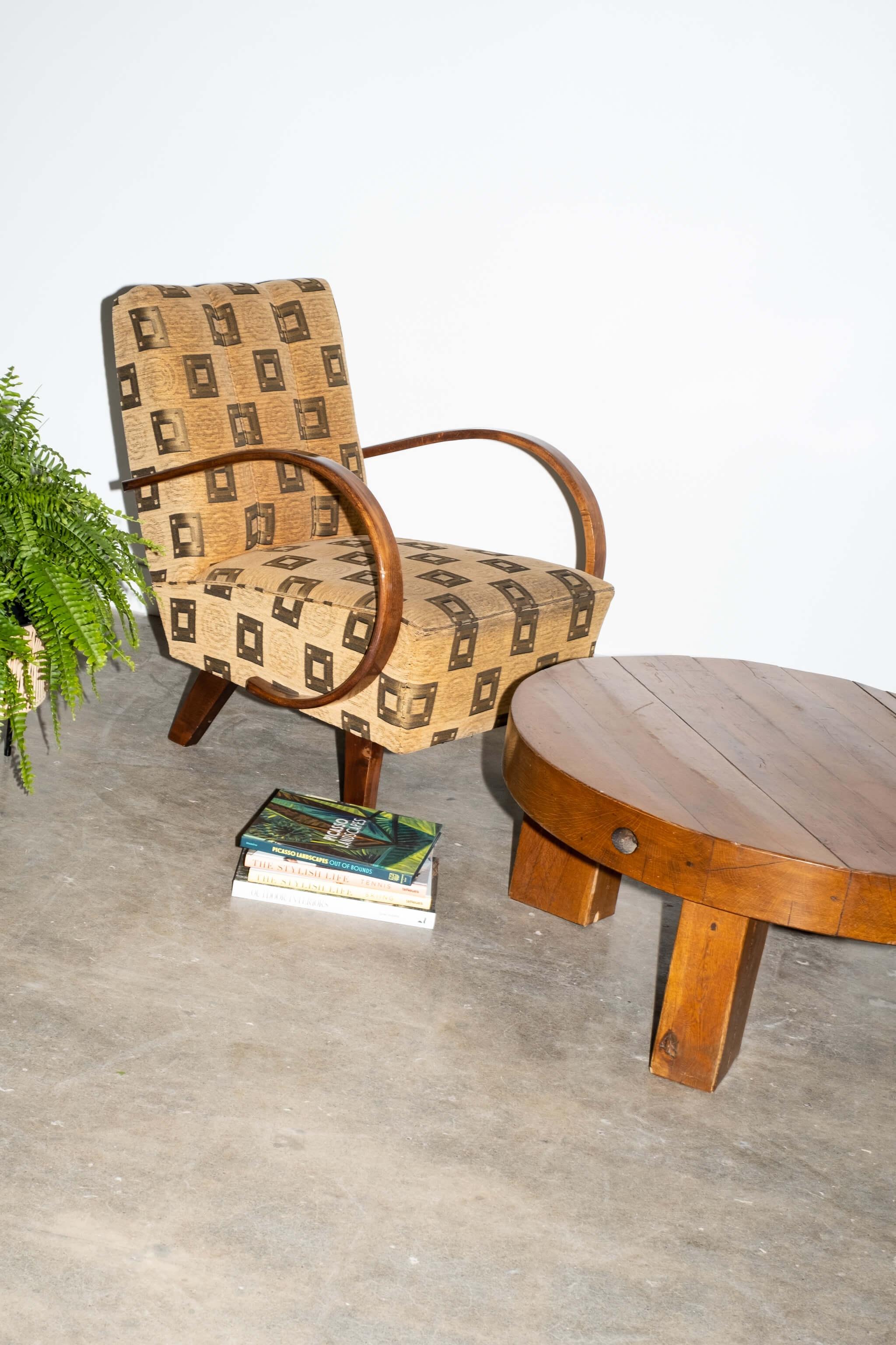 Le lourd plateau rond de cette table basse de style brutaliste repose simplement sur 4 blocs de bois. Simplicité, chaleur et rusticité.