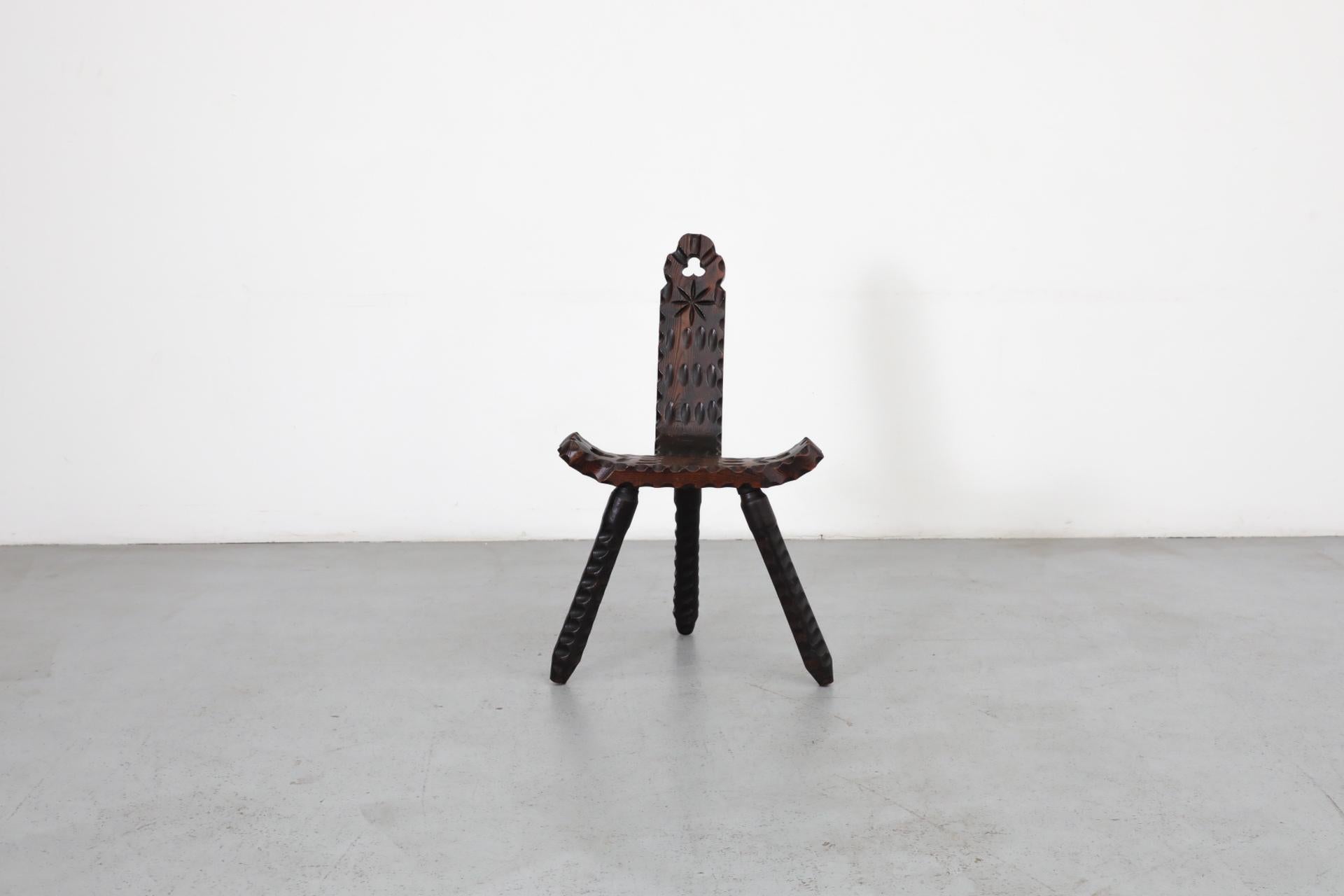 Brutalist Spanish fireside chair with tripod legs, curved seat and decorative carving. In original condition with visible wear consistent with its age and use. Shown with matching stool, listed separately (LU922443143652).
