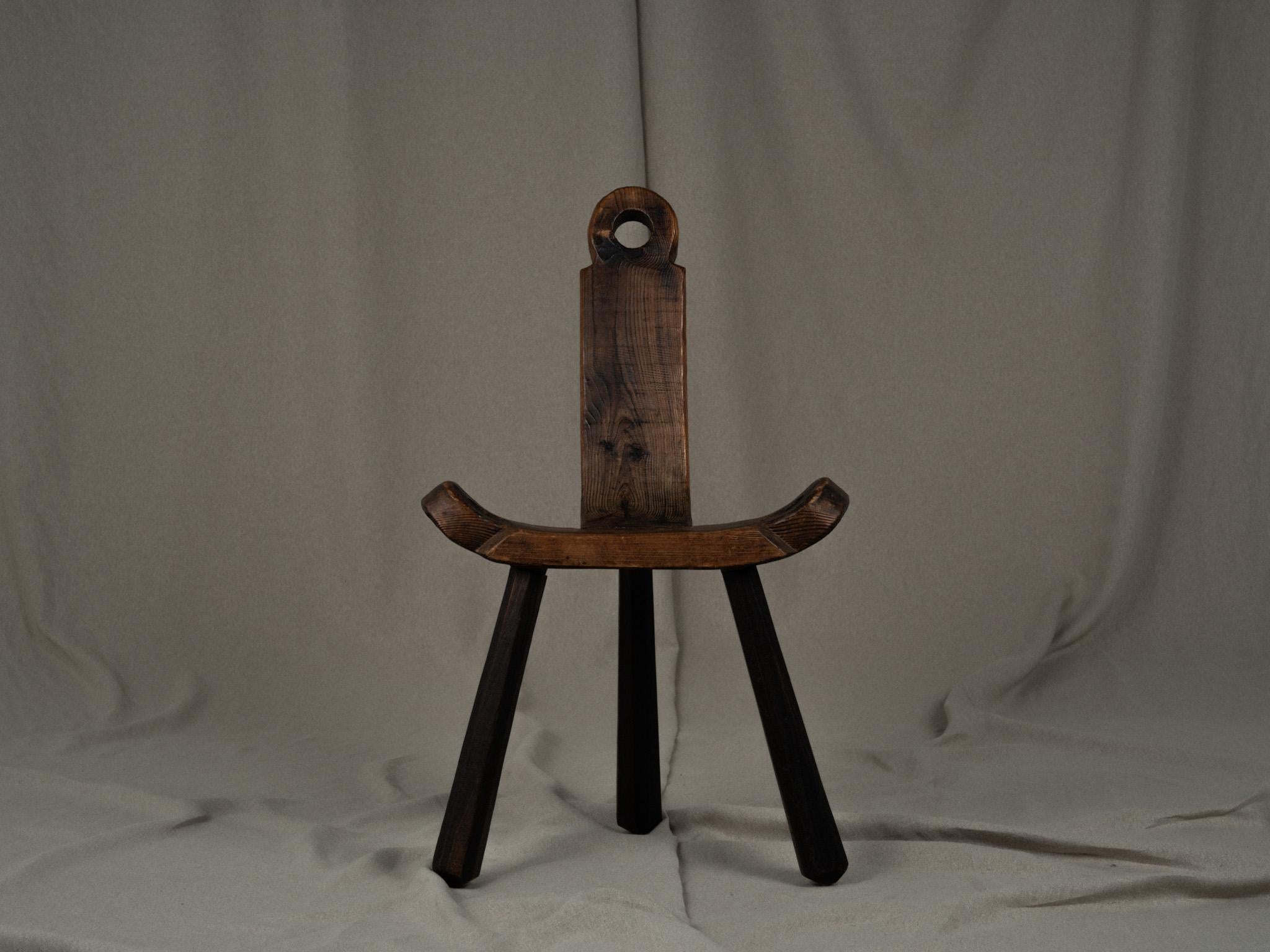 Chaise tripode primitive en bois craquelé. Un bel objet brutaliste avec une belle patine. Fabriqué à la main au début du 20e siècle. Fabriquée en bois massif, elle a été utilisée historiquement comme chaise d'accouchement. Assise rectangulaire