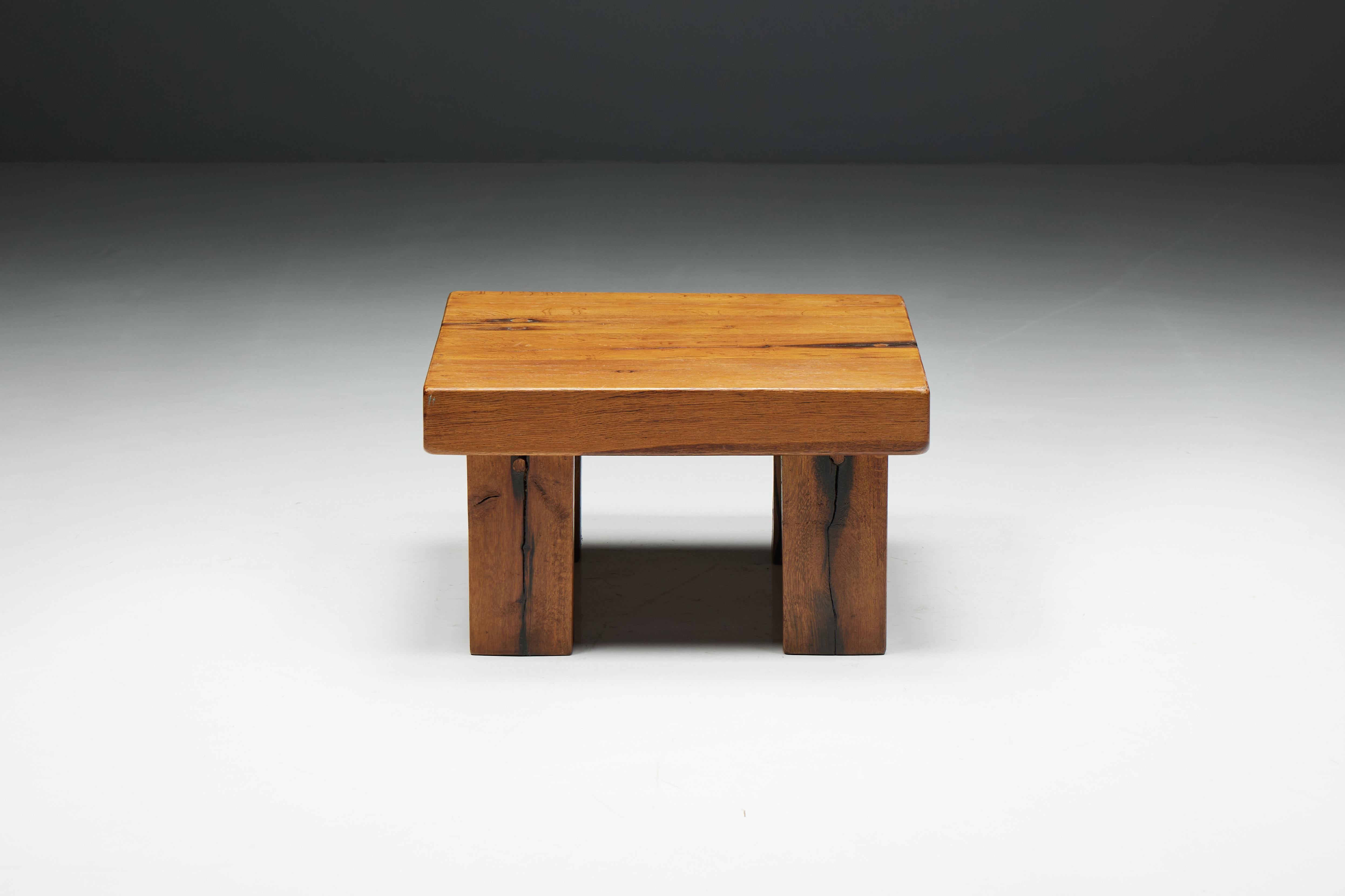 Rustic square brutalist coffee table with a four-legged base, crafted from solid wood with an inviting patina. The square surface offers space for objects like books, magazines, and other curiosities. It can also function as a side table. This