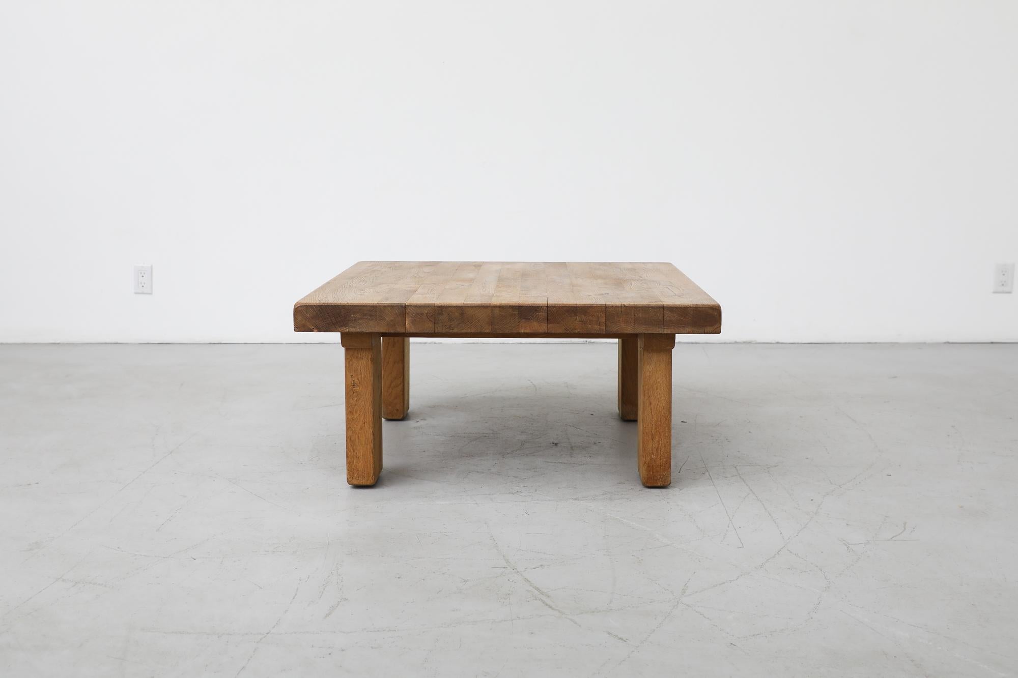 Beautiful midcentury heavy oak square coffee table with clean boxy design, exposed support beams and thick rectangular legs. This table is in original condition with visible signs of wear consistent with its age and use.