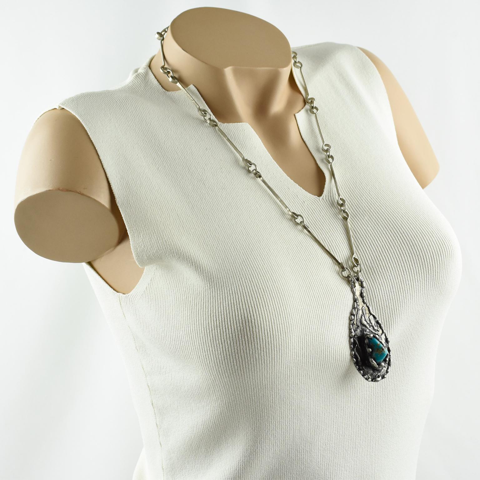 Stunning 1970s brutalist long pendant necklace. Featuring a stainless steel long worked links chain, compliment with a huge drop pendant, in textured stainless steel topped with a turquoise stone. Hook closing clasp. No visible maker's