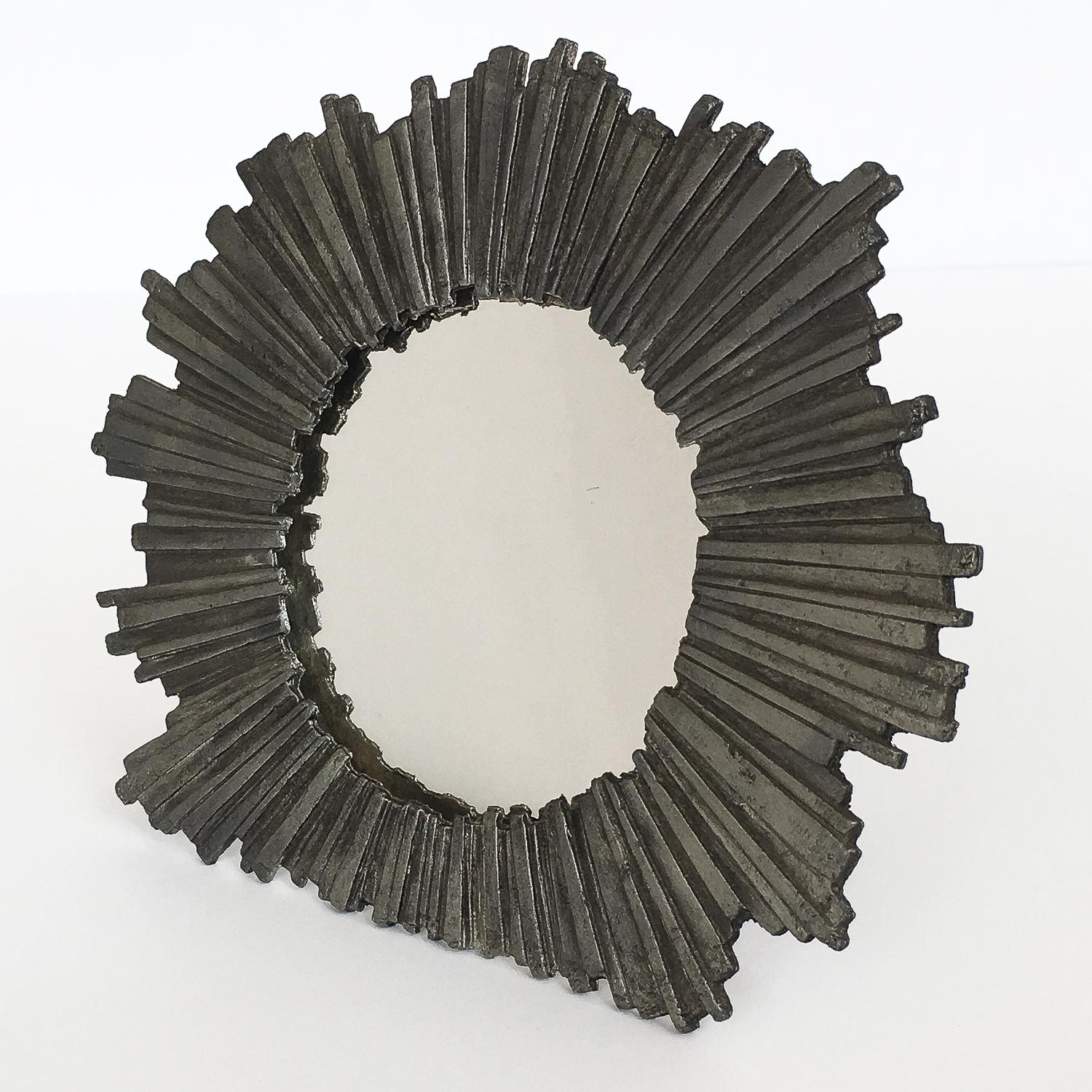 Brutalist Metzke pewter starburst framed mirror, circa 1978. Stylized solid pewter frame surrounds a small round mirror. Could also be used as a picture frame. Easel backing for table top use. The frame could also be hung on the wall using the small