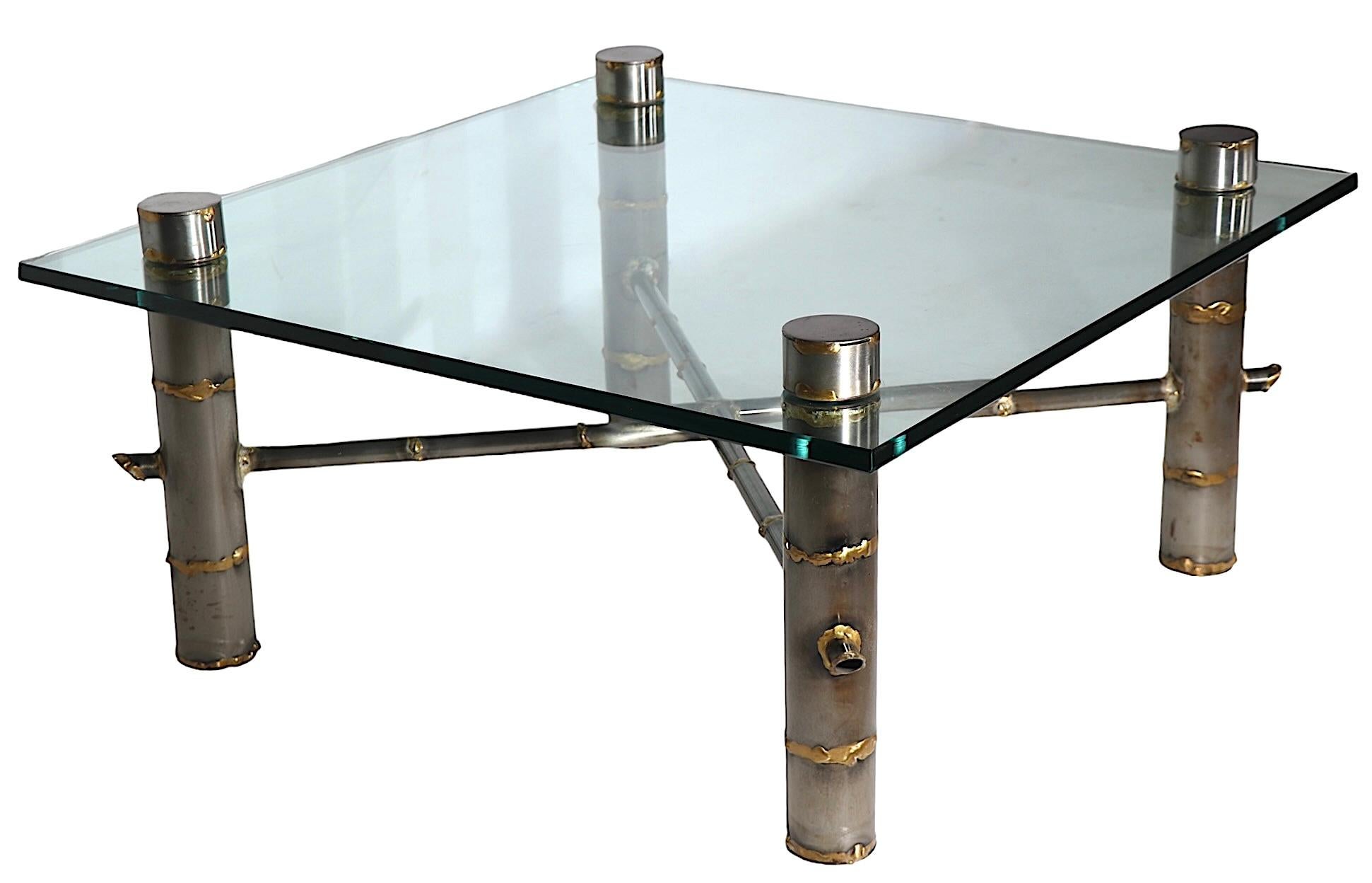 Brutalist coffee table, having a faux bamboo steel and brass base, which supports a thick tempered square glass top ( 36 x 36 in. ).  Executed in the style of Paul Evans, Silas Seandel, Mastercraft, etc. this example is unsigned. 
 The metal base