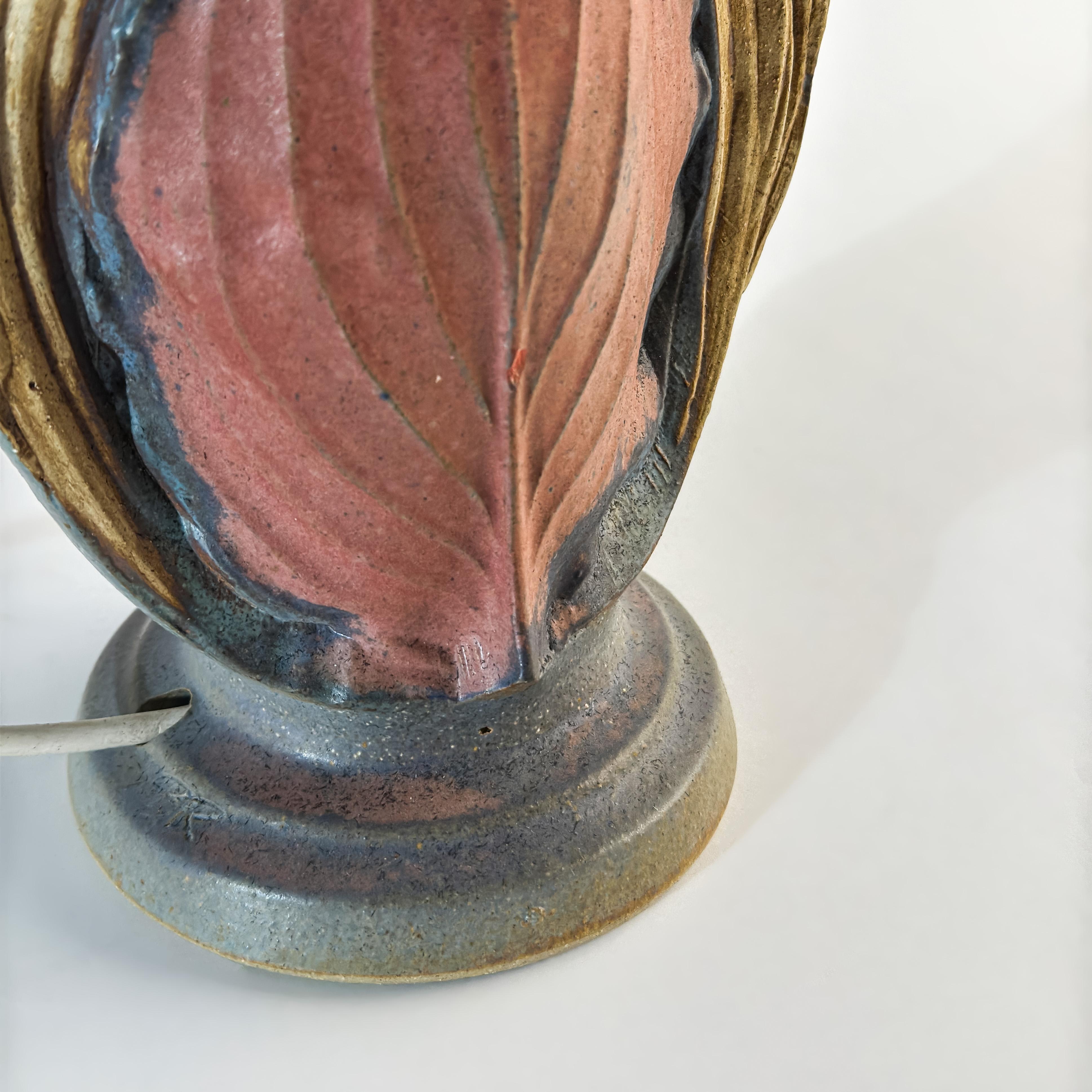 A sculptural mid-20th century table lamp by renowned British ceramicist Bernard Rooke, handcrafted in England during the 1960s. Exemplifying Brutalist ceramic lighting with an organic twist, this taller, oval-bodied form reflects Rooke’s refined