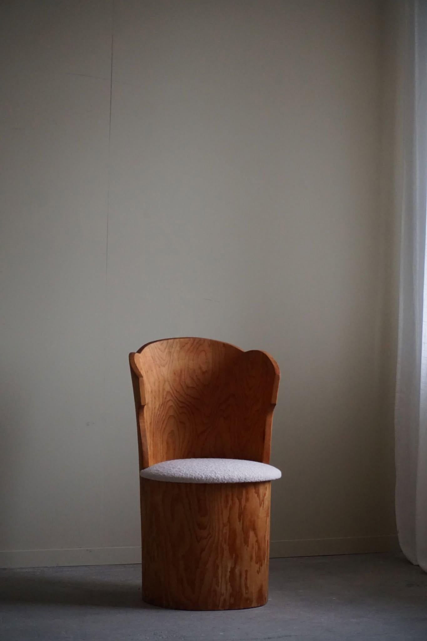Sculptural rustic stump chair made in solid pine. Hand carved by a Swedish cabinetmaker in the 1970s. Beautiful wood grains in this vintage piece, a truly authentic brutalist piece. The seat cushion reupholstered in bouclé, Tiree 1002 (Sand) from