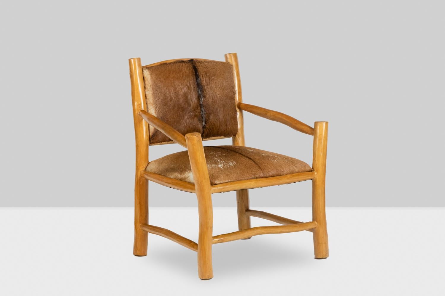 Brutalist style armchair in solid natural blond elm, with its seat and back in goatskin. Three spacer bars.