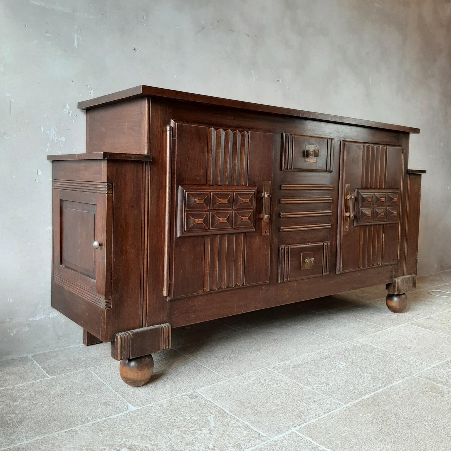 Brutalist style brown oak sideboard, credenza by Charles Dudouyt, 1940s-1950s. This midcentury cabinet features 2 large doors on each side, and in the middle 2 drawers with large storagespace inside. The doors and drawers panels are beautifully