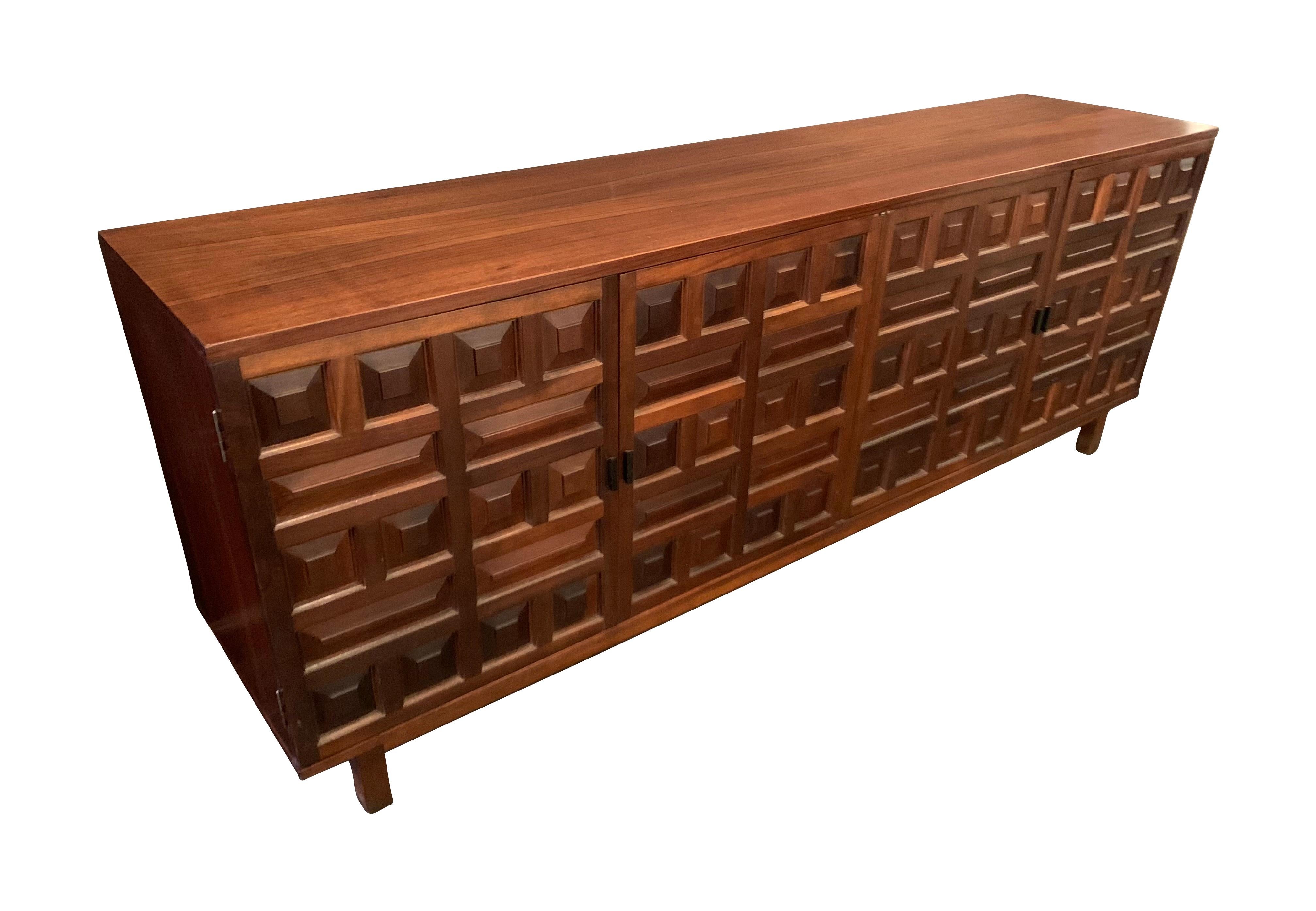 1970's Spanish brutalist style four door credenza.
Raised panel three dimensional design on doors.
Mahogany and beech wood.
Four inner drawers and four inner shelves.
Recently refurbished.