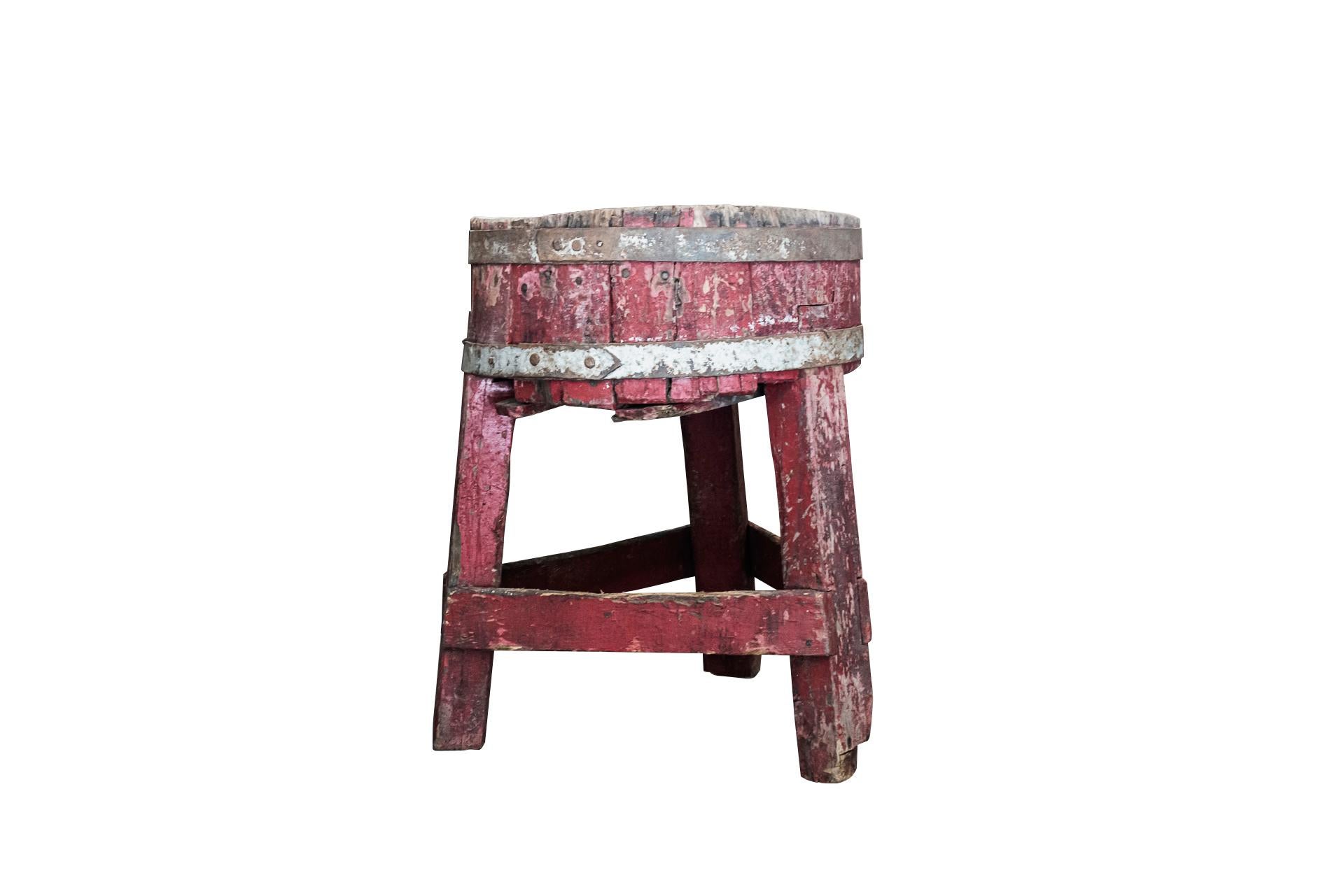 Brutalist style, Tripod butcher's chopping block, 
Natural wood and red stained wood with iron rim, 
circa 1900, France.

Measures: Diameter 60 cm, height 80 cm.