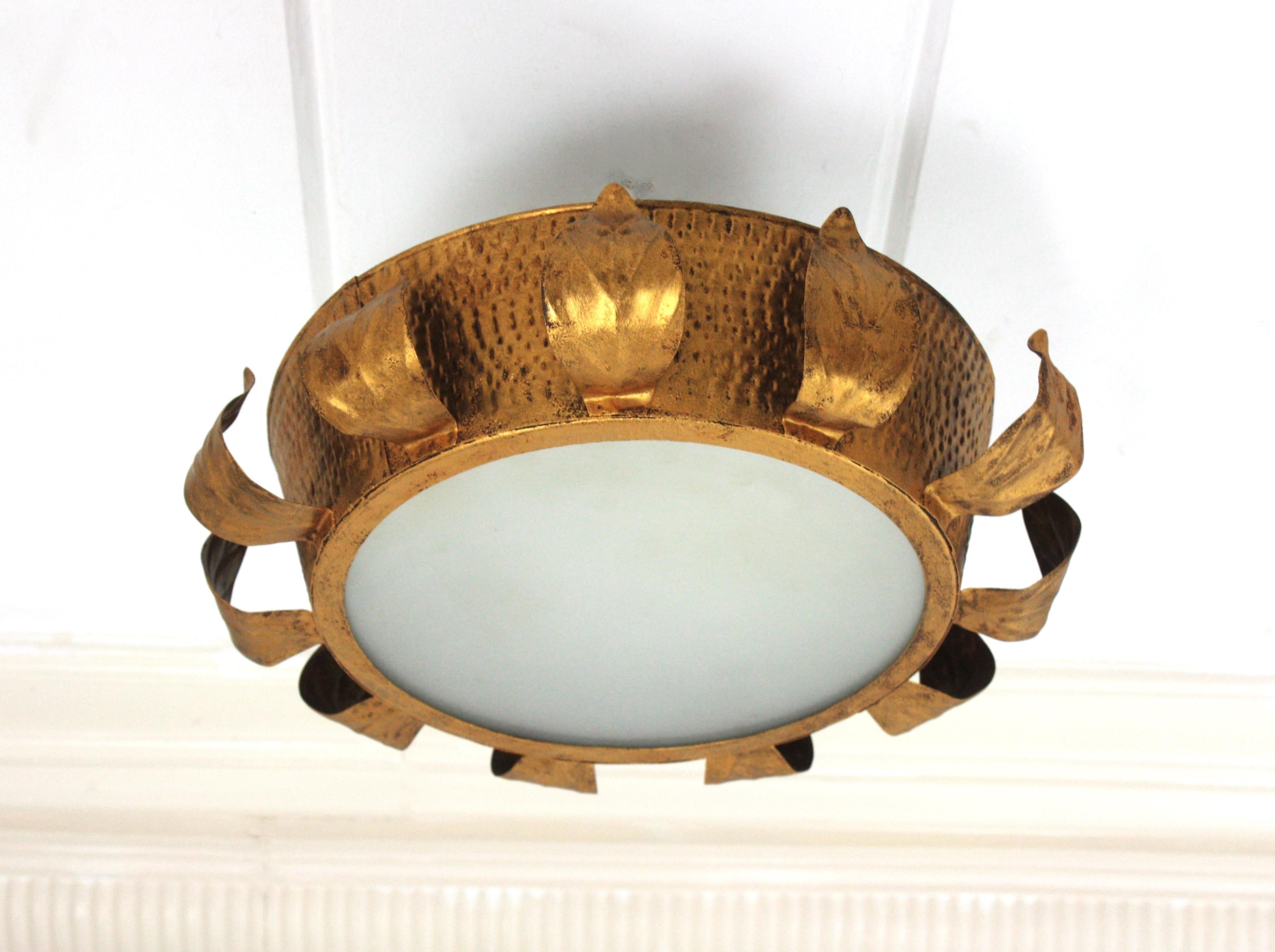 Sunburst Crown Flush Mount with Foliage Details, Gilt Iron, Frosted Glass
Hand-hammered iron  sunburst crown ceiling light fixture with frosted glass panel difusser. Spain, 1950s.
This ceiling flush mount was handcrafted in Spain at the Mid-Century
