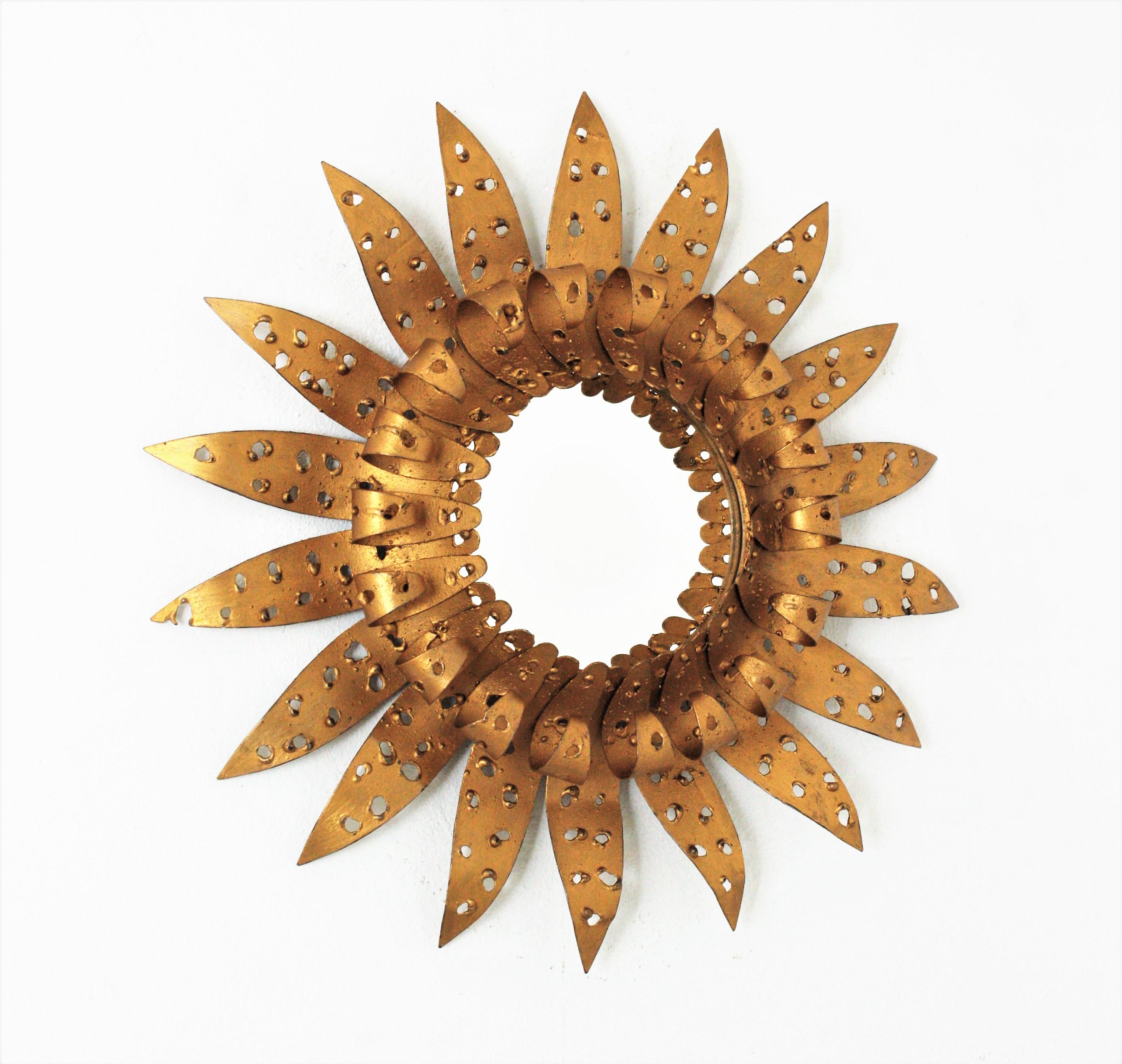 French Brutalist gilt metal sunburst mirror, 1950-1960.
Unusual brutalist perforated iron sunburst mirror with eyelash rays surrounding the glass.
This sunburst mirror has perforations thorough, this brutalist design marks the difference.
Beautiful