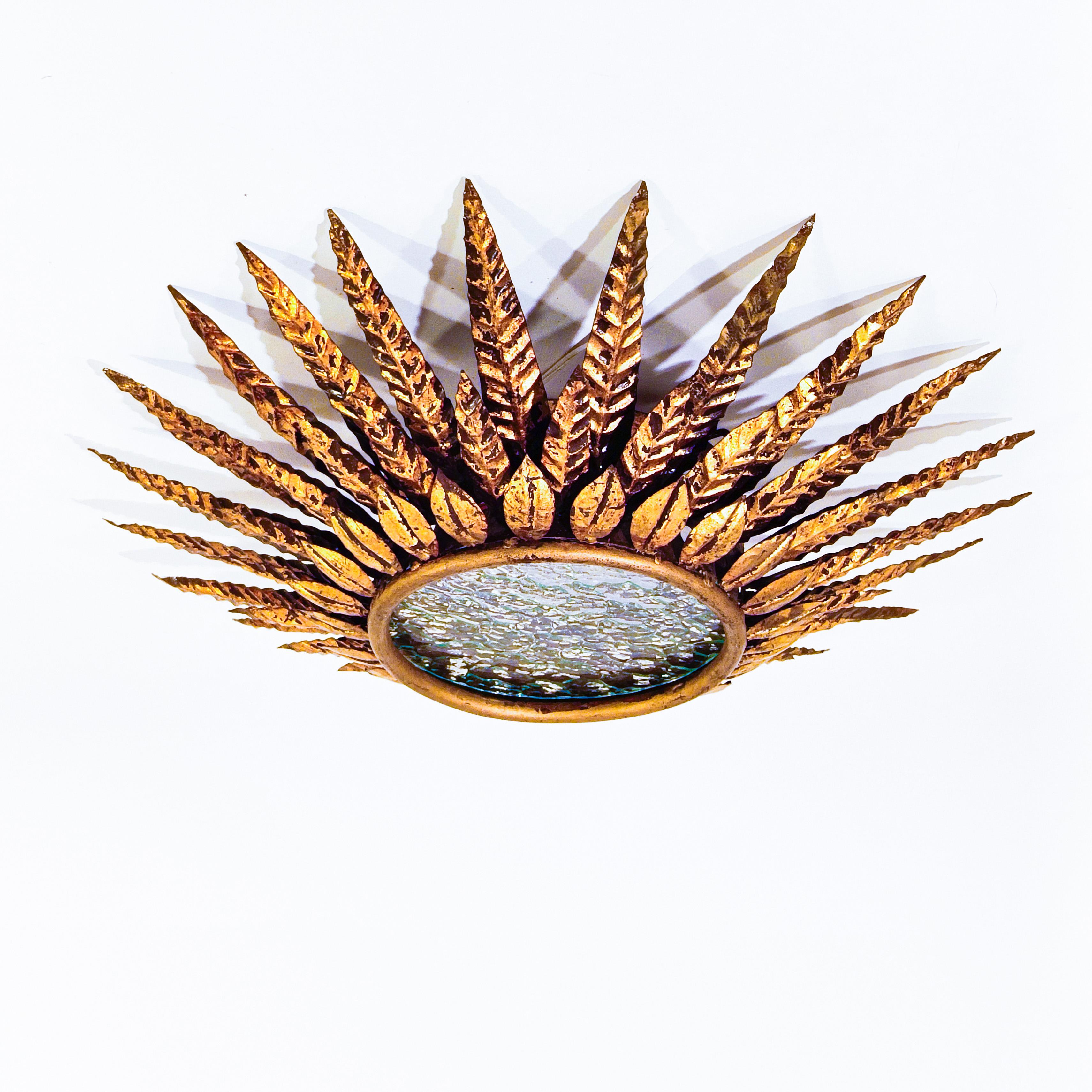 Large brutalist sun-style ceiling lamp from Ferro Art (also known as Ferroarte), Spain, 60s. Metal structure finished in gold leaf and formed by a circular iron base where different sheets of various sizes are welded as a crown around its perimeter.