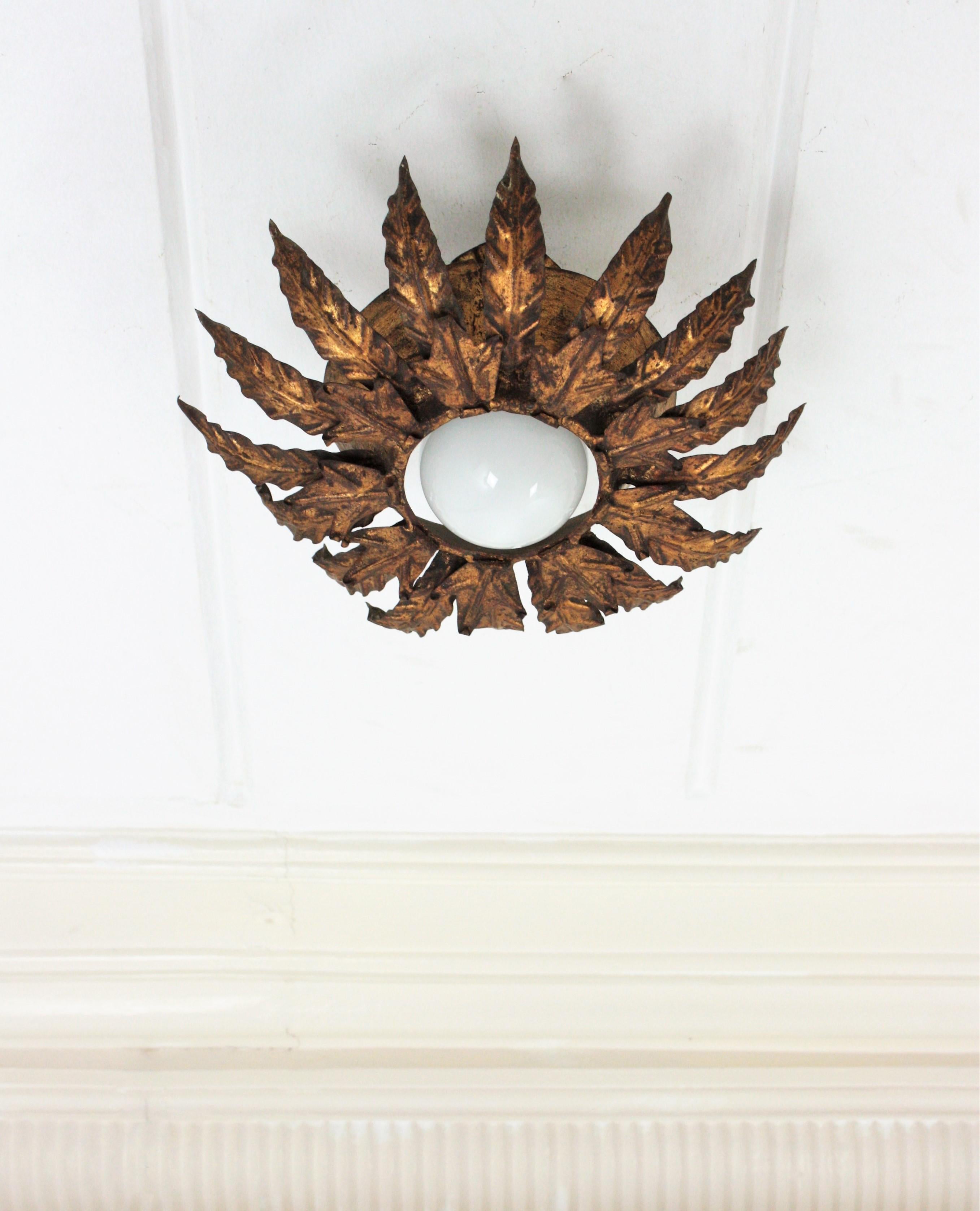 Brutalist Leafed Flower sunburst flush mount, gilt iron, gold leaf, Spain, 1950s.
Eye-catching light fixture made of iron featuring two layers of leaves gilded iwith gold leaf surrounding a central light with an exposed bulb. It has a terrific