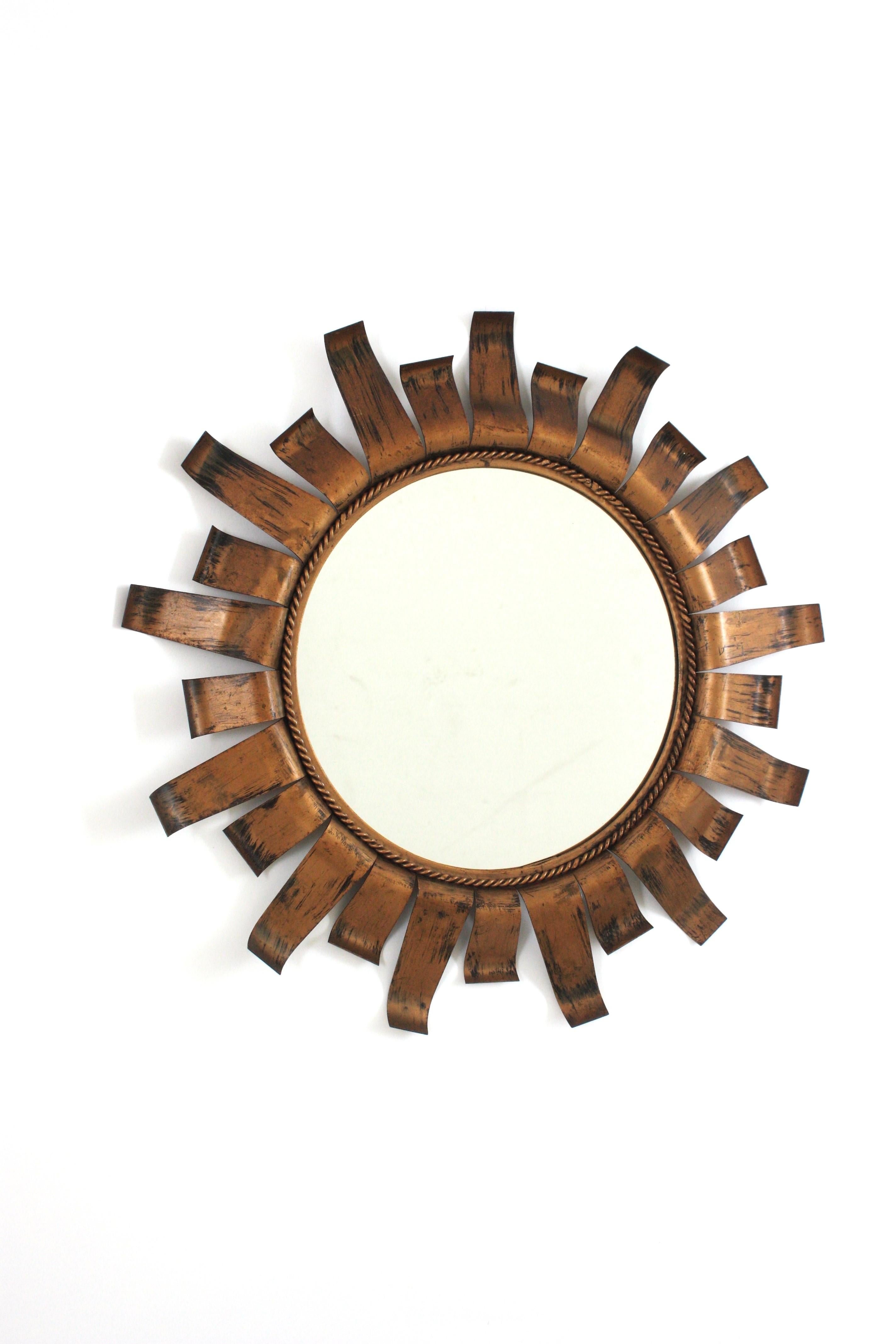 Espejo Sunburst de Hierro Patinado Dorado
Espejo Sunburst con pátina de bronce dorado y diseño brutalista, España, años 50
Este espejo sunburst se hizo totalmente a mano. Tiene un marco con rayos alternos de dos tamaños con terminaciones cortadas.