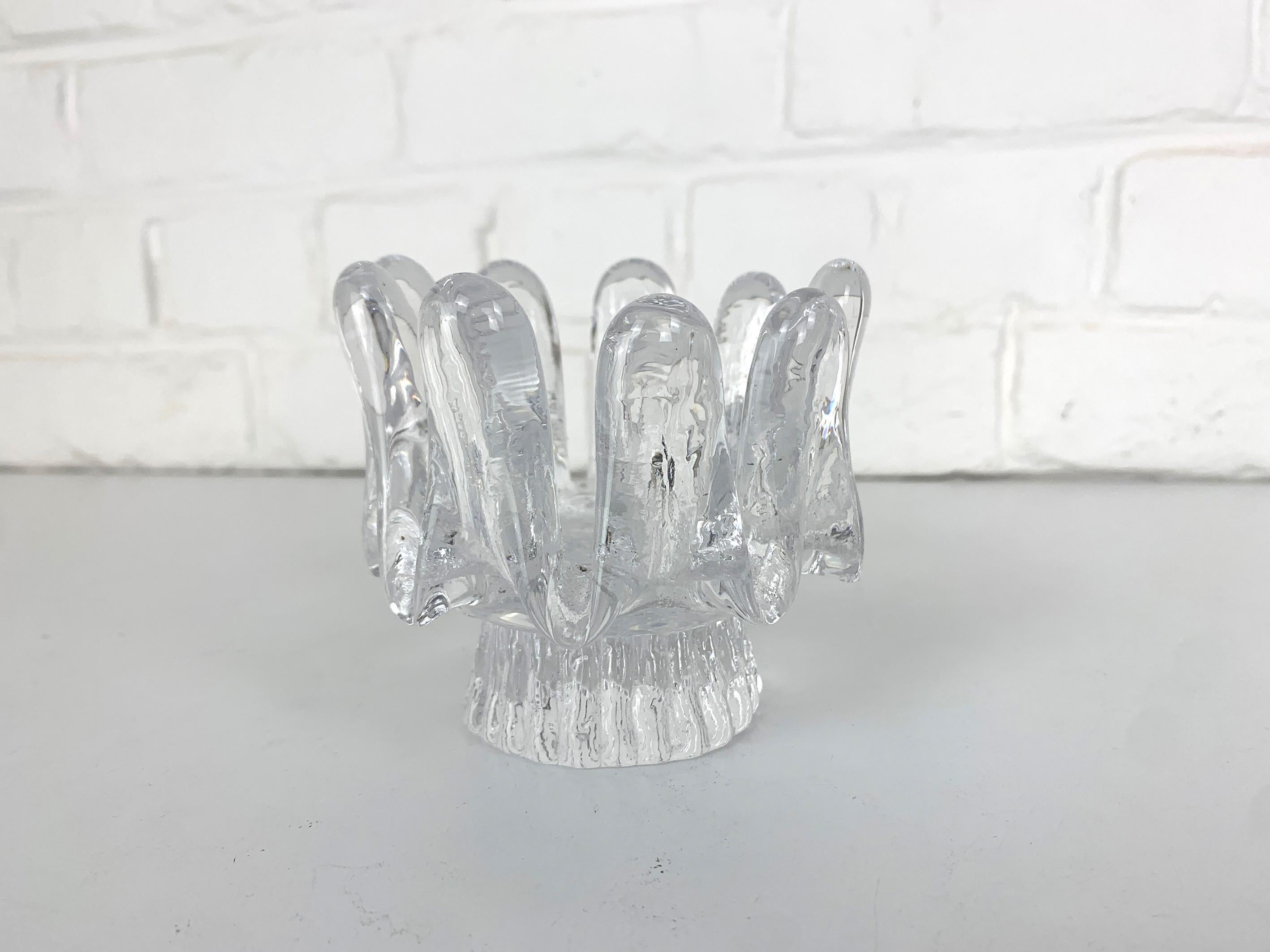 Crystal glass candlestick, design by Göran Warff for Kosta Boda, Sweden in the 1970s.

Groovy mid-century design classic from Scandinavia. Great design in colourless glass with a brutalist touch. 

For tea-lights or large round candles with a