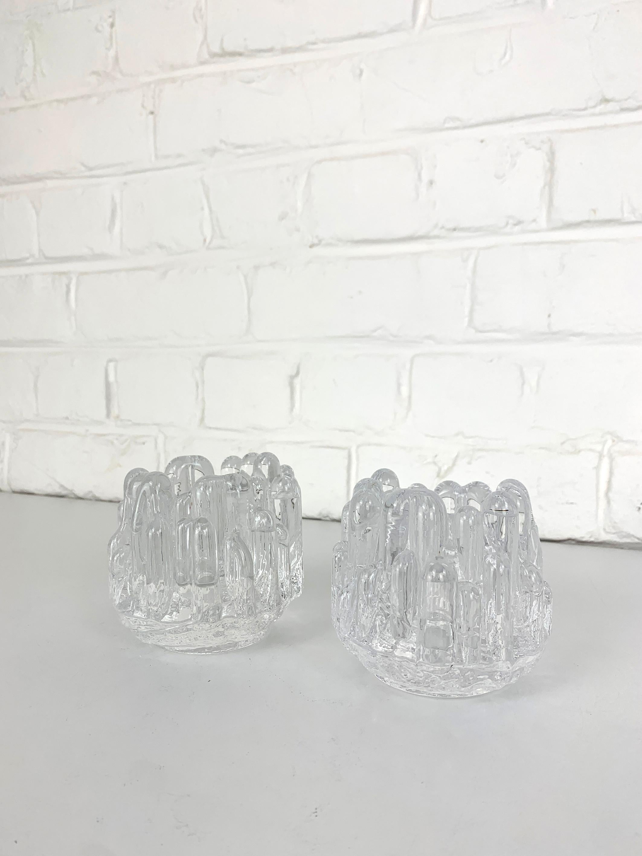 Portacandele in cristallo, design di Göran Warff per Kosta Boda, Svezia, anni Settanta. Set di 2.

Un classico del design scandinavo di metà secolo. Grande design in vetro incolore con un tocco brutalista. 

Per candele da tè o candele rotonde di