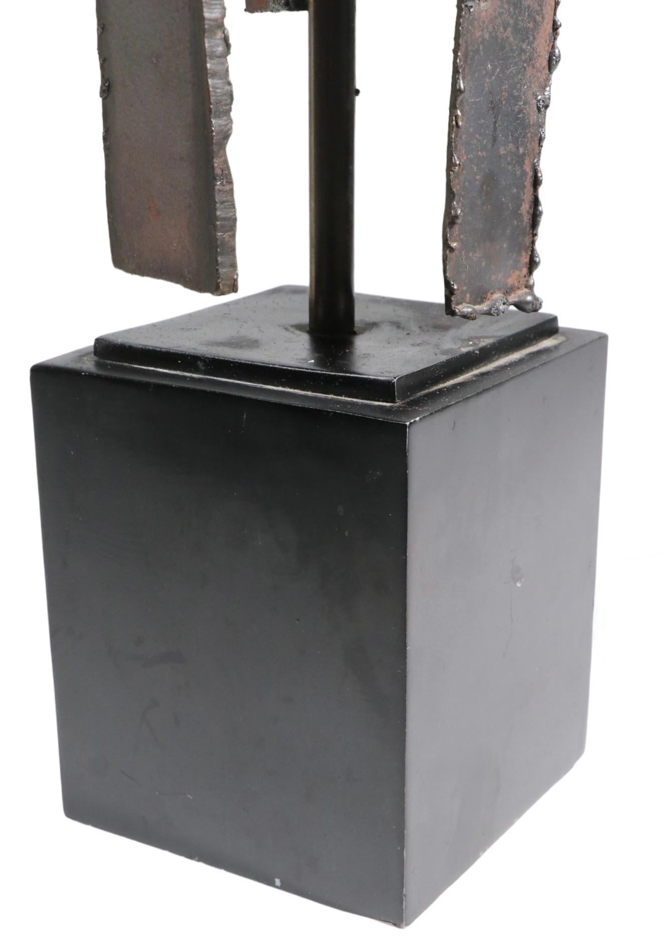 Lampe de table brutaliste iconique, par Harry Blamer, pour la Laurel Lamp Company vers les années 1970. La lampe présente un corps découpé au chalumeau à partir de segments de fer soudés, monté sur une base rectangulaire en forme de socle. Cet