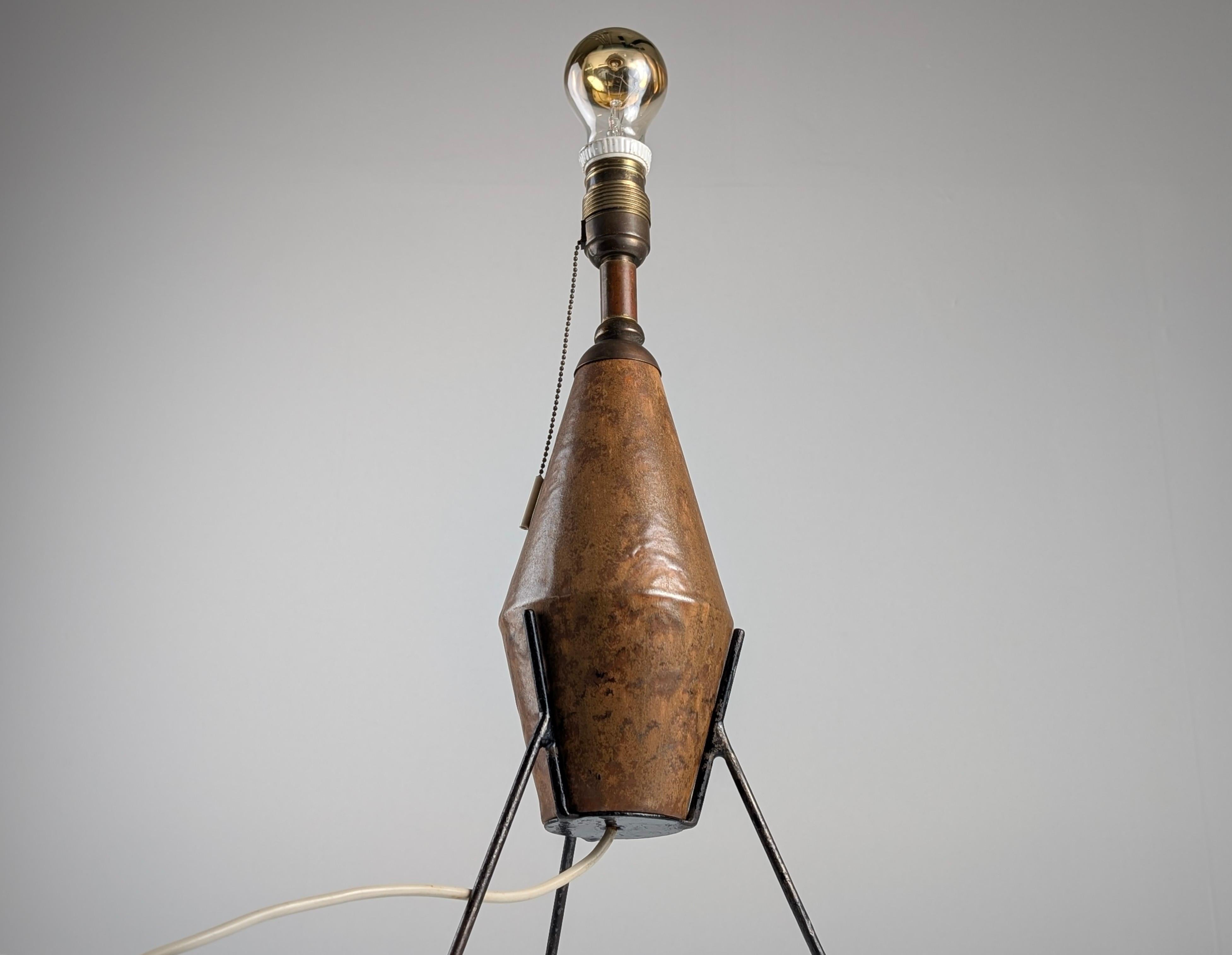 Avec une imposante présence sculpturale, cette lampe de table incarne l'essence du brutalisme à travers son design géométrique et sa matérialité brute. La base en céramique émaillée présente une patine riche en teintes terreuses, avec une texture