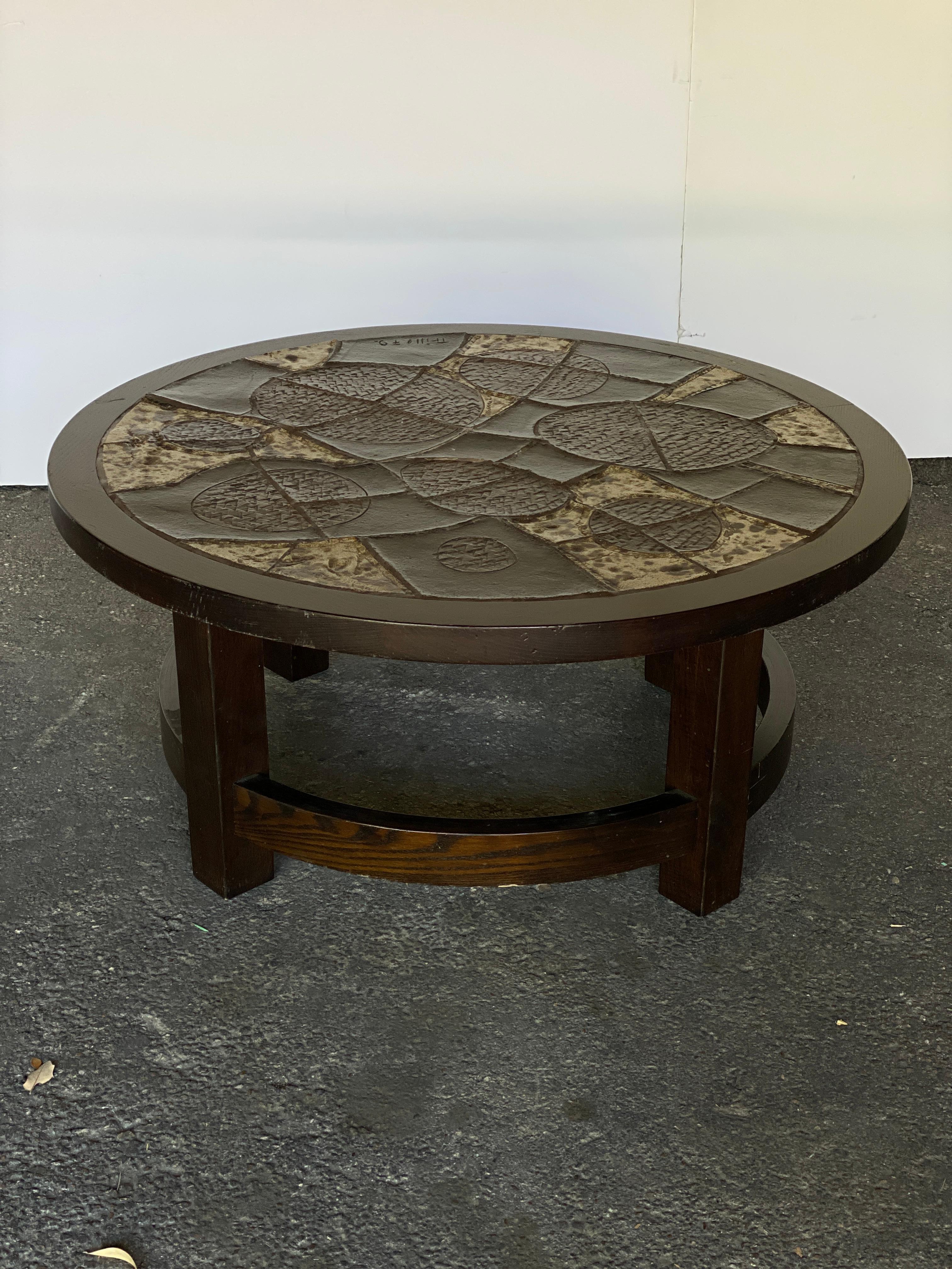 Mid-Century Modern round cocktail table in the Brutalist style with rustic ceramic tile top and wood base (probably stained oak.) Signed. Belgium, 1960-70's.