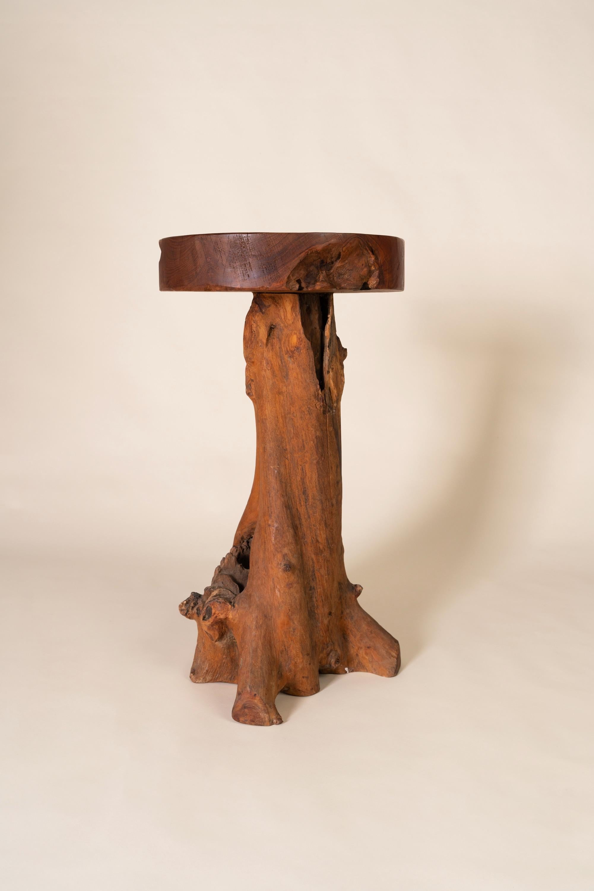 Cette table d'appoint du milieu du XXe siècle est un exemple frappant de modernisme organique, fabriqué en bois massif avec un fort accent sur la forme et la texture naturelles. La table est dotée d'un épais plateau rond dont la surface lisse et